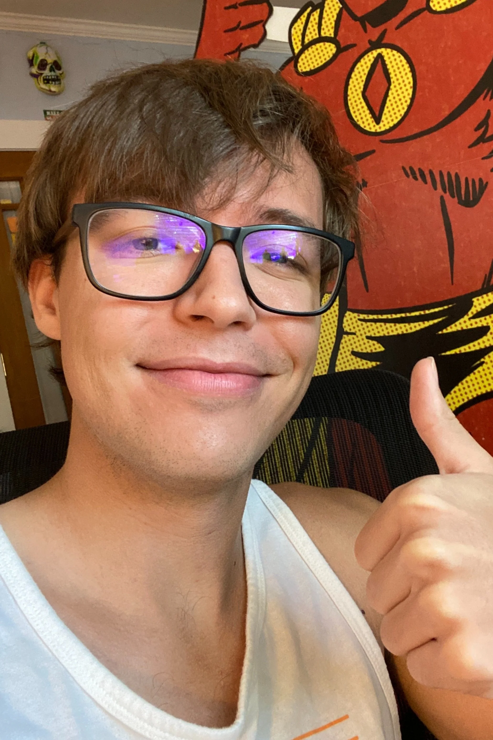 Breyden Boyd's headshot photo. He is wearing glasses and a tank top, and is giving a thumbs up. Shape-Man is in the background.