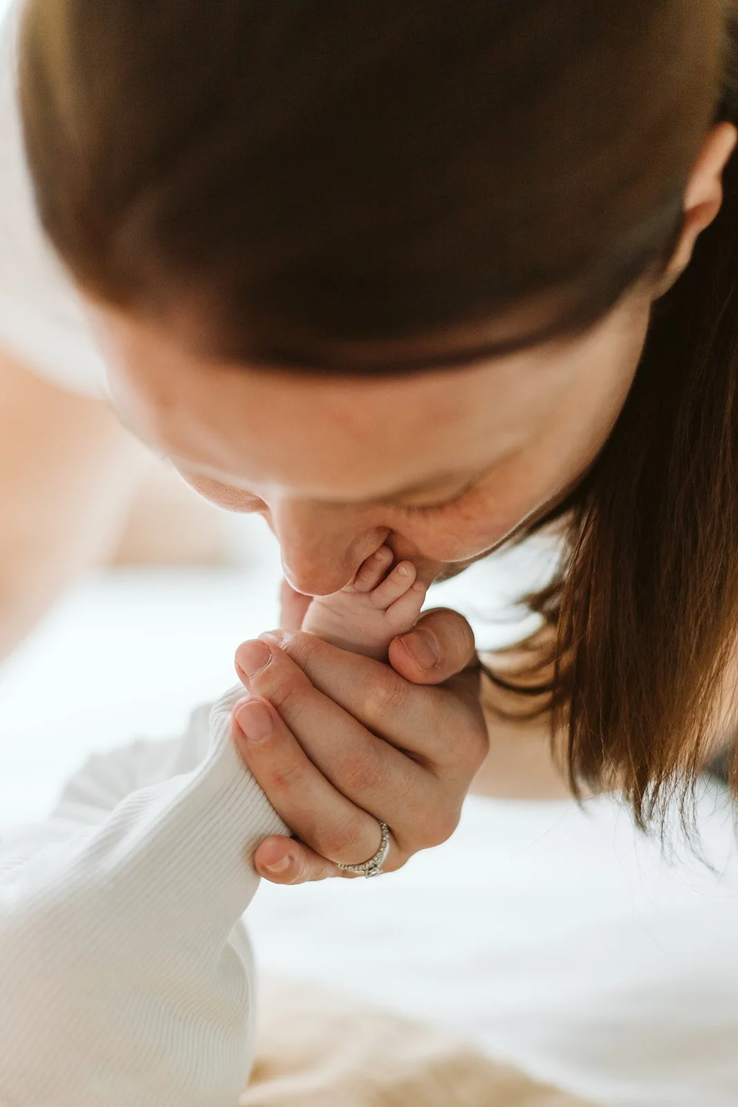 Une femme embrasse un bébé avec tendresse, montrant un geste affectueux et intime.