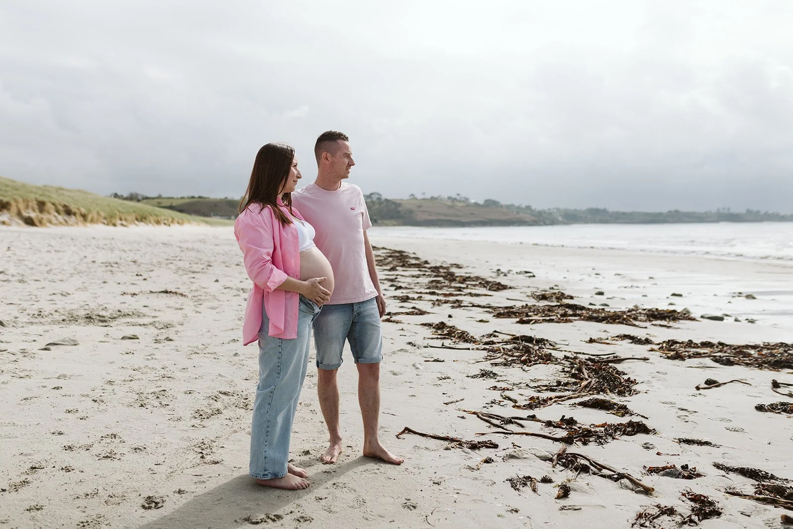 un couple est sur la plage avec une femme enceinte