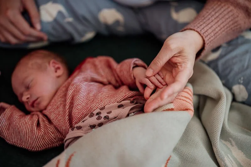 Mama-haelt-neugeborenes-hand-wochenebett.jpg