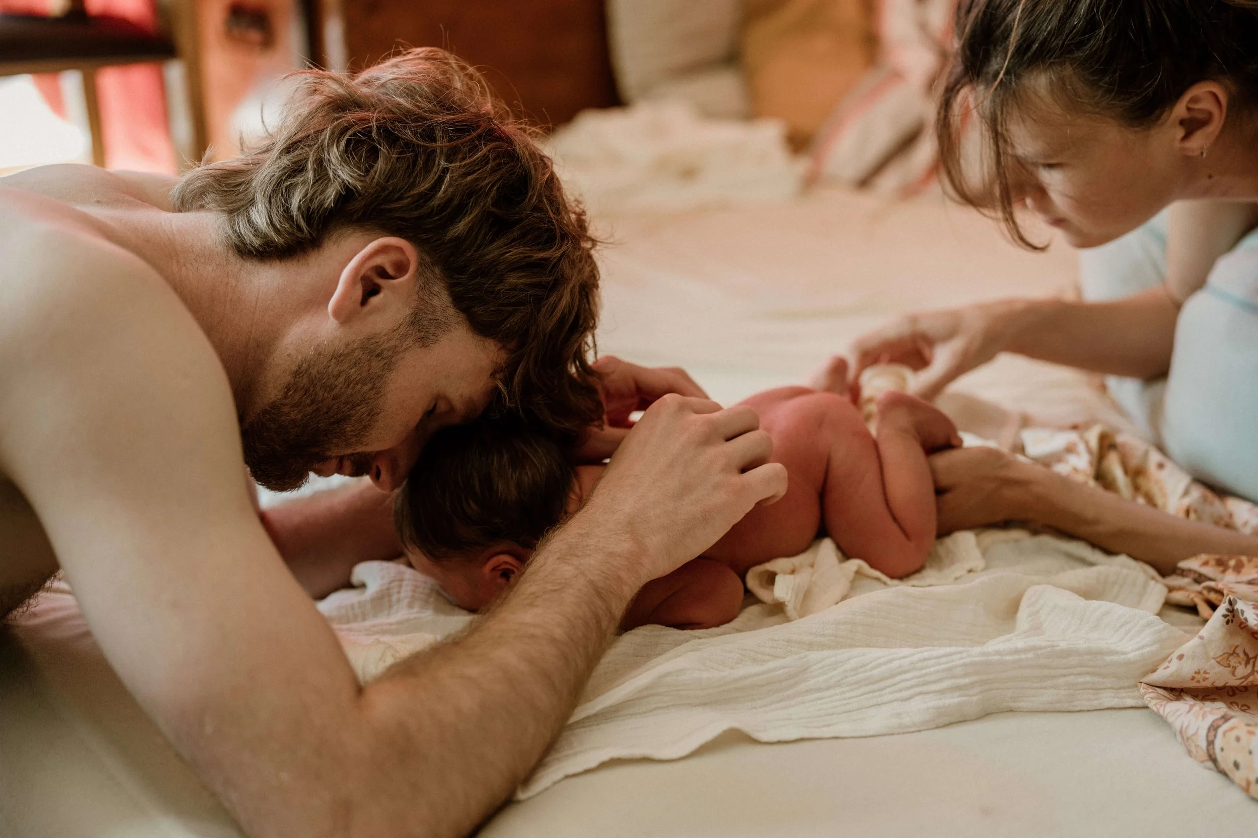 neugeborenes mit eltern im wochenbett
