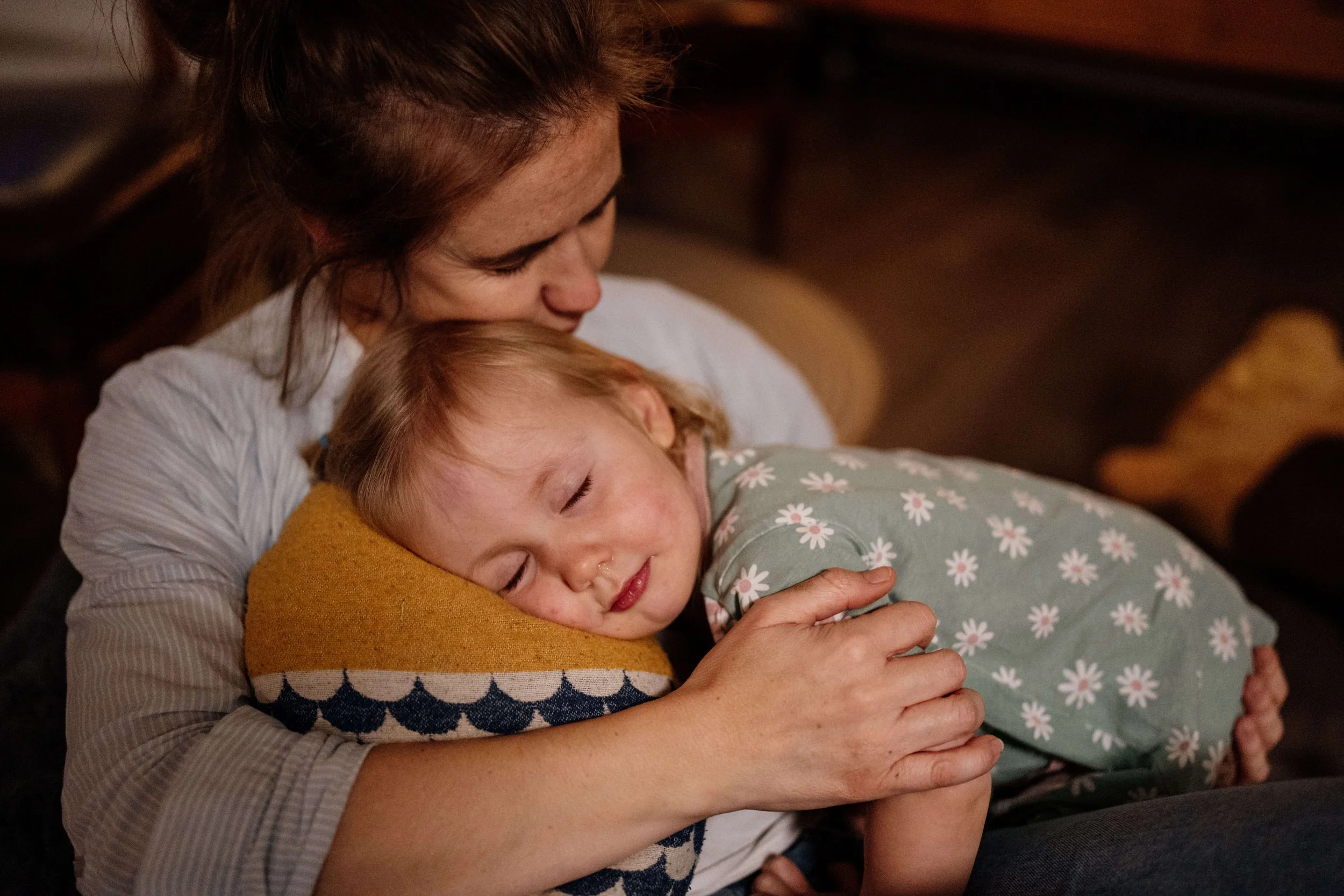 Kleinkind kuschelnd in Mamas arm mit geschlossenen Augen