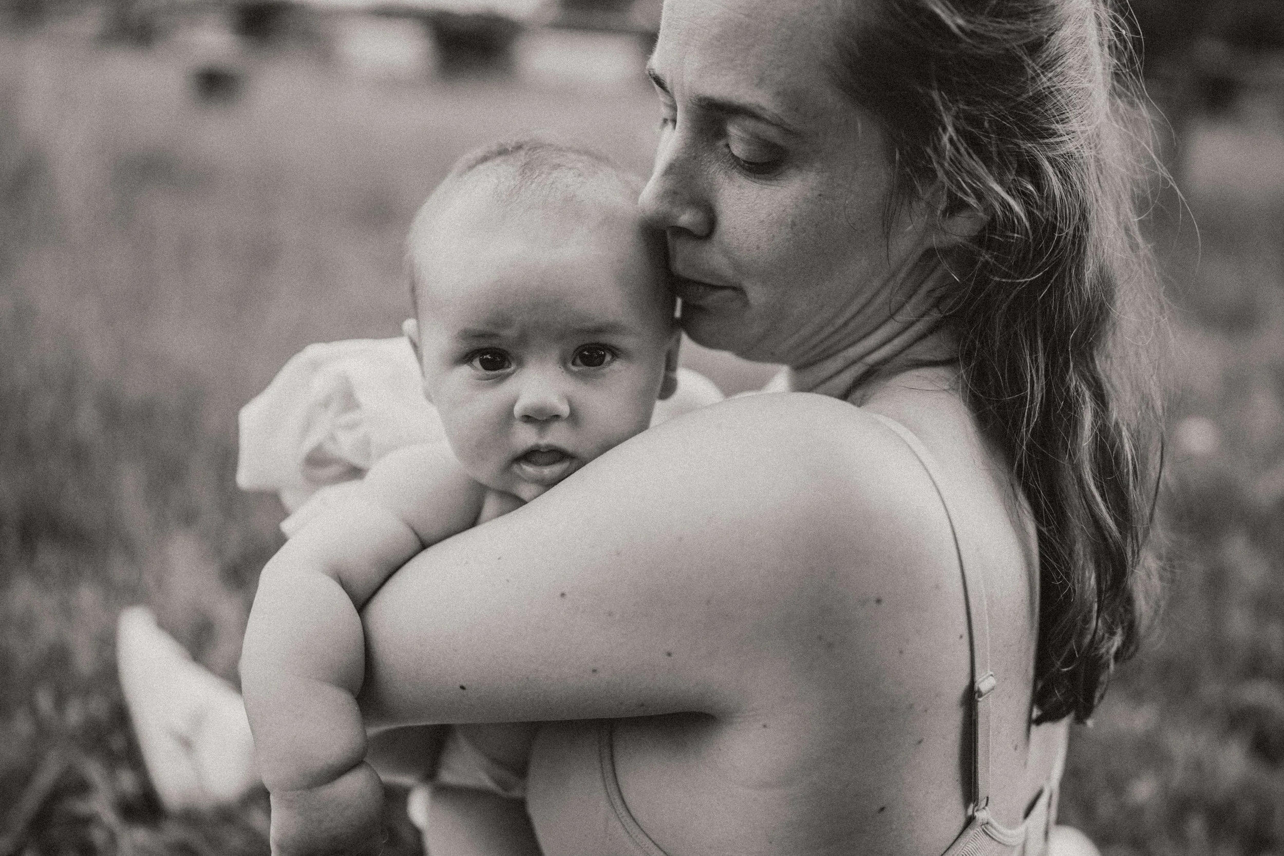 Baby auf mamas arm im Garten
