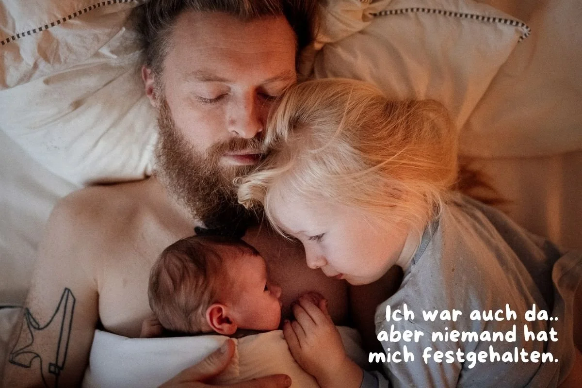 Vater schlafend im Bett und auf ihm kuschelnd ein neugeborenes und ein Kleinkind das sich an den Haenden halten und in die Augen schauen