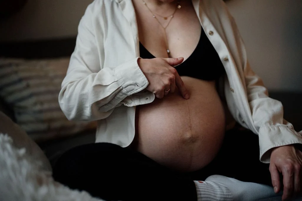 Nahaufnahme Hand auf Schwangerenbauch, intime Detailfotografie Schwangerschaft