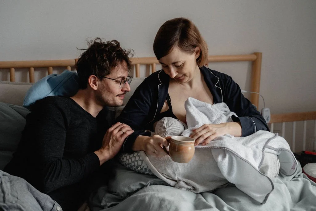 Eltern bestaunen gemeinsam ihr Neugeborenes im Wochenbett, Wunder des Lebens dokumentiert