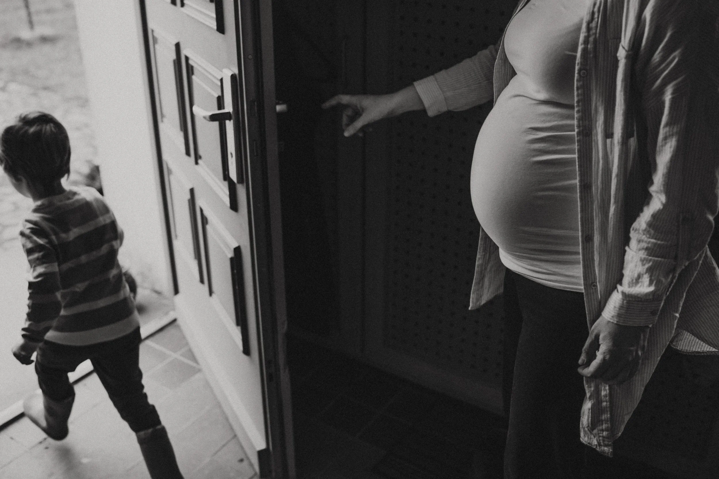 Schwarz weiß bild einer schwangeren die hinter kleinkind herläuft