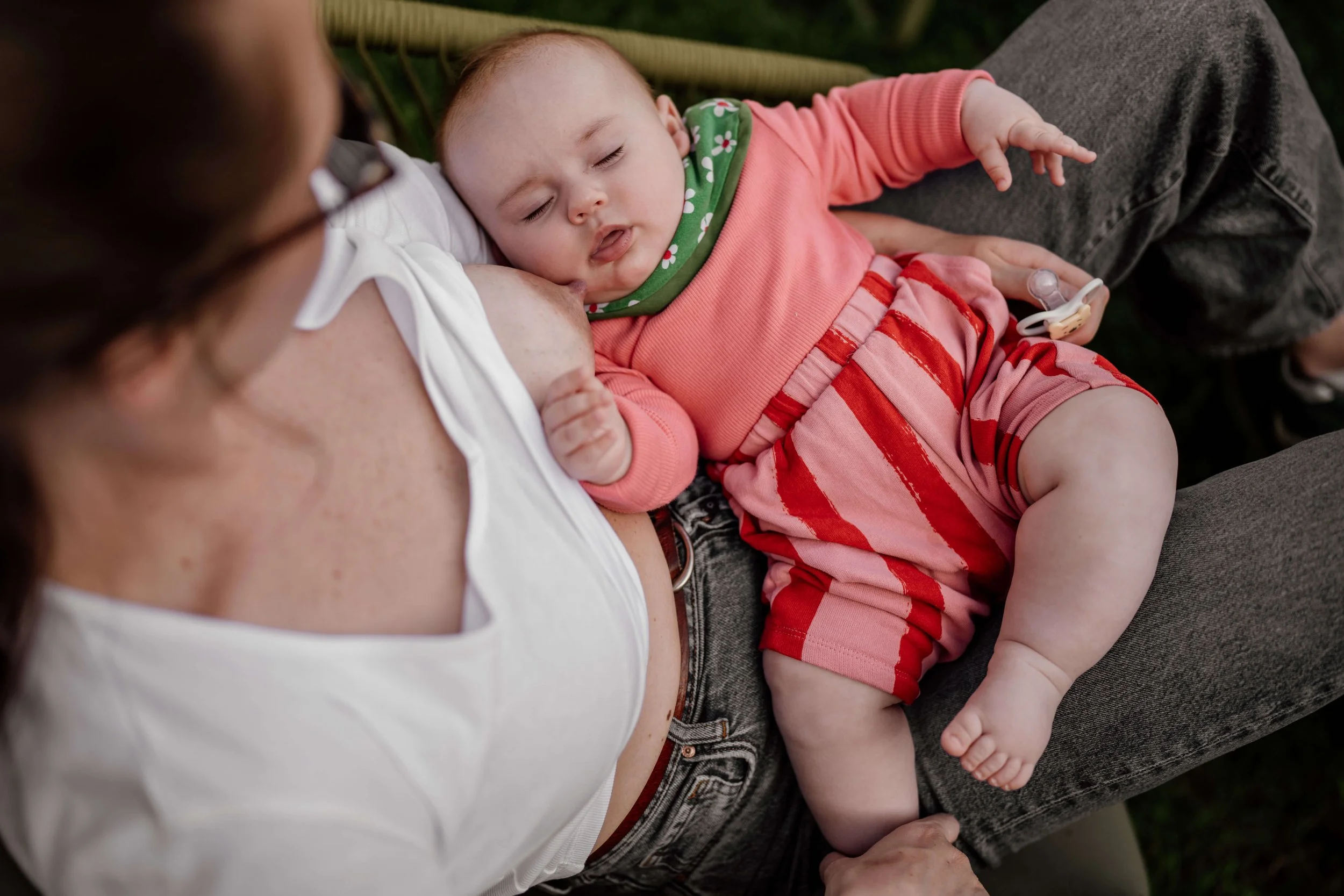 Baby schlafend nach dem Stillen auf Mamas schoß