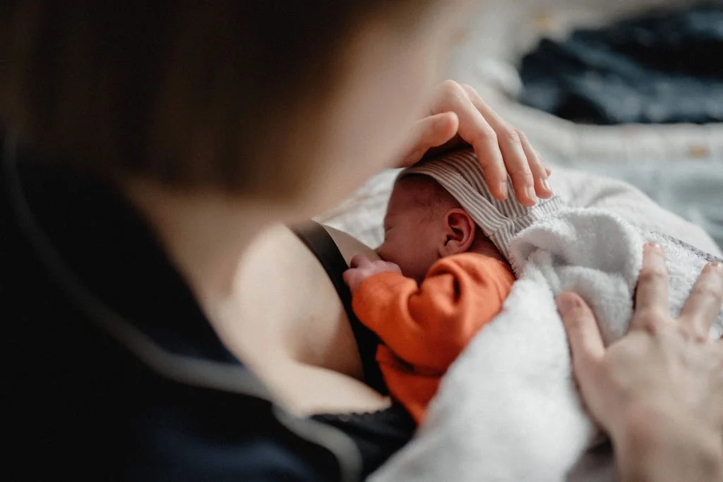 Mutter stillt Neugeborenes im Wochenbett, intime Stillmomente dokumentarisch festgehalten