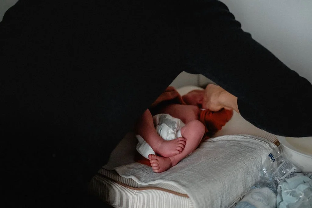 Detailaufnahme Vater wickelt Neugeborenes, winzige Babyfüße