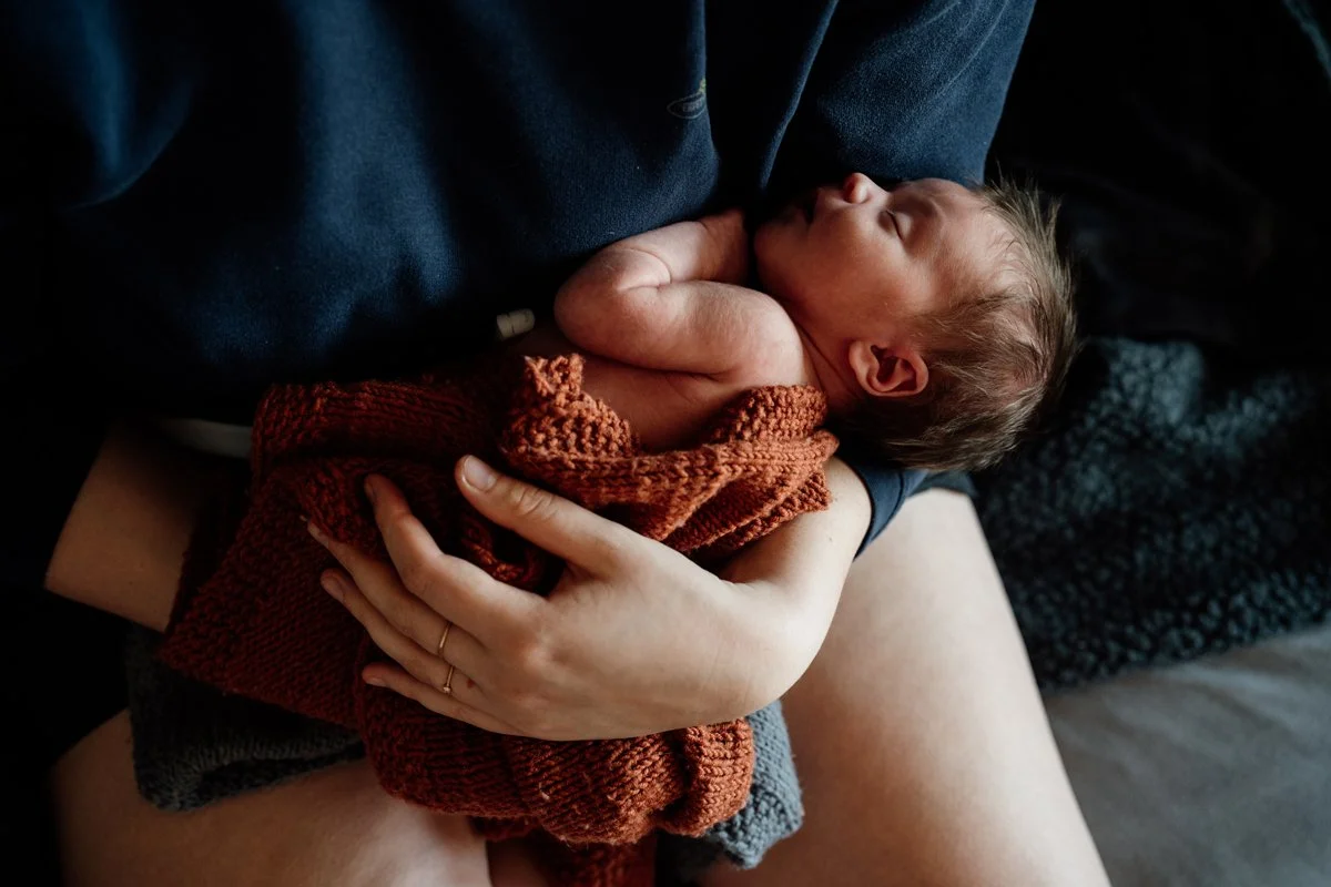 Neugeborenes liegt in Mamas Arm und schläft