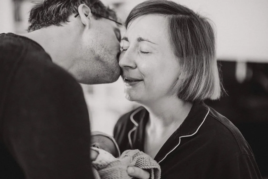 Emotionale Mutter mit Neugeborenem im Wochenbett, echte Gefühle dokumentarisch festgehalten