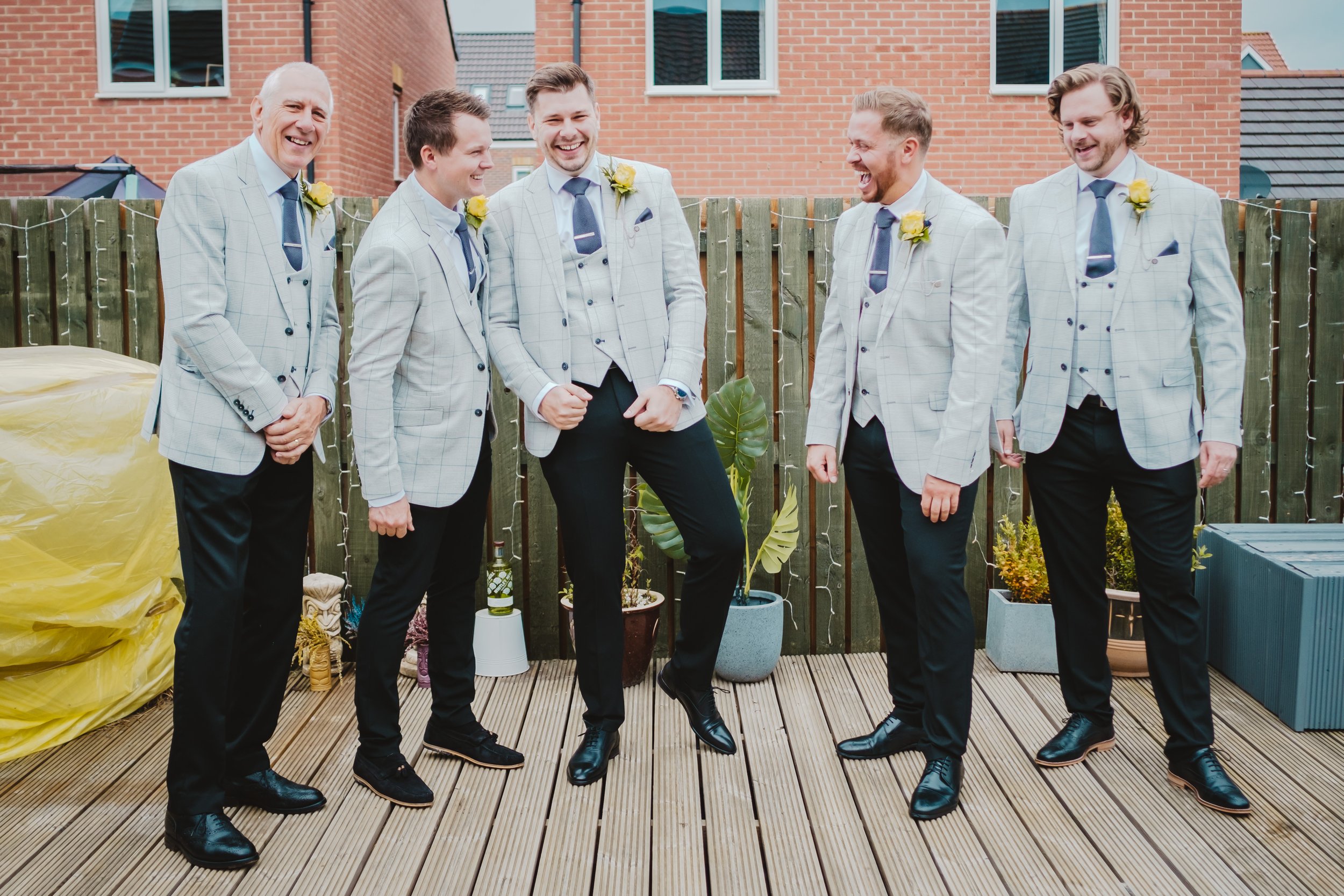 The groom and his merry men standing outside having a laugh.