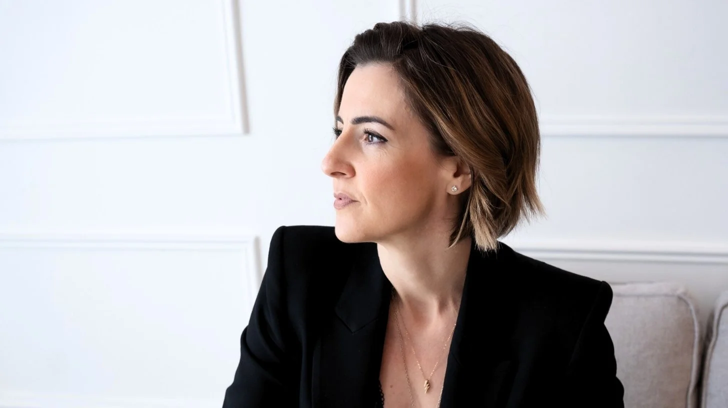 Lisa Moore, Sovereign Frequency Architect and Founder of House of Soul Sovereignty, seated in side profile in a black blazer, gazing forward with quiet authority and calm certainty