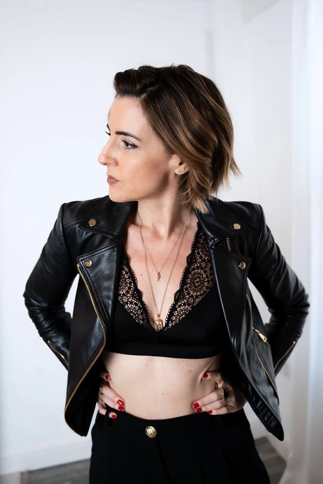 Lisa Moore, Sovereign Frequency Architect, in a black leather jacket with hands on hips, exuding sovereign confidence