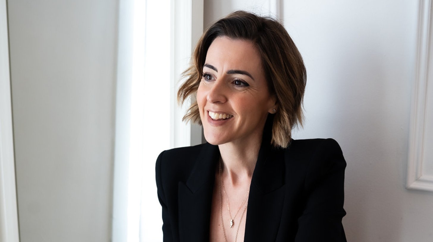 Lisa Moore, Sovereign Frequency Architect and Founder of House of Soul Sovereignty, smiling warmly in a black blazer, looking to the side with ease and presence. Caption: Lisa Moore, Sovereign Frequency Architect
