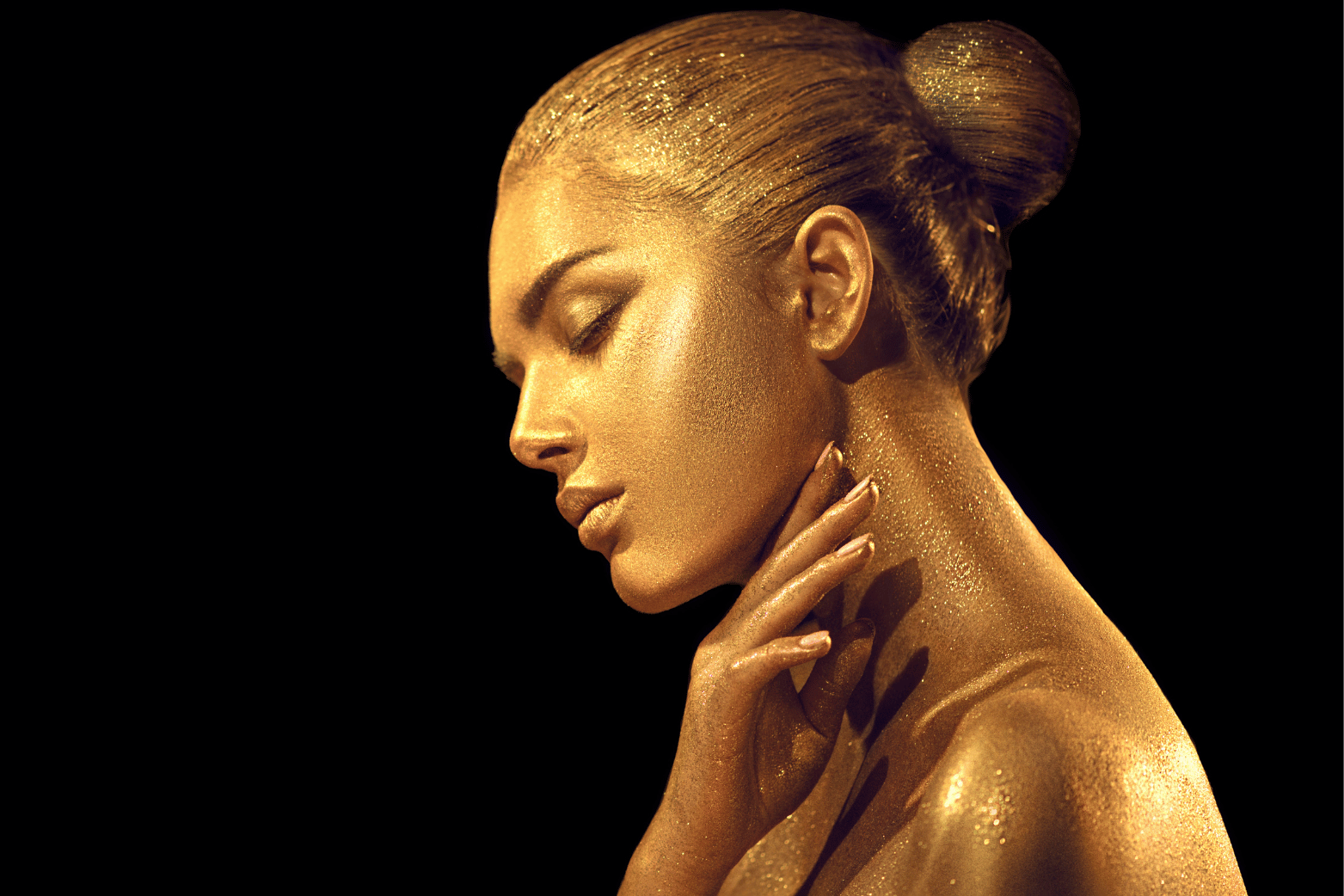 gold woman on black background looking inwards