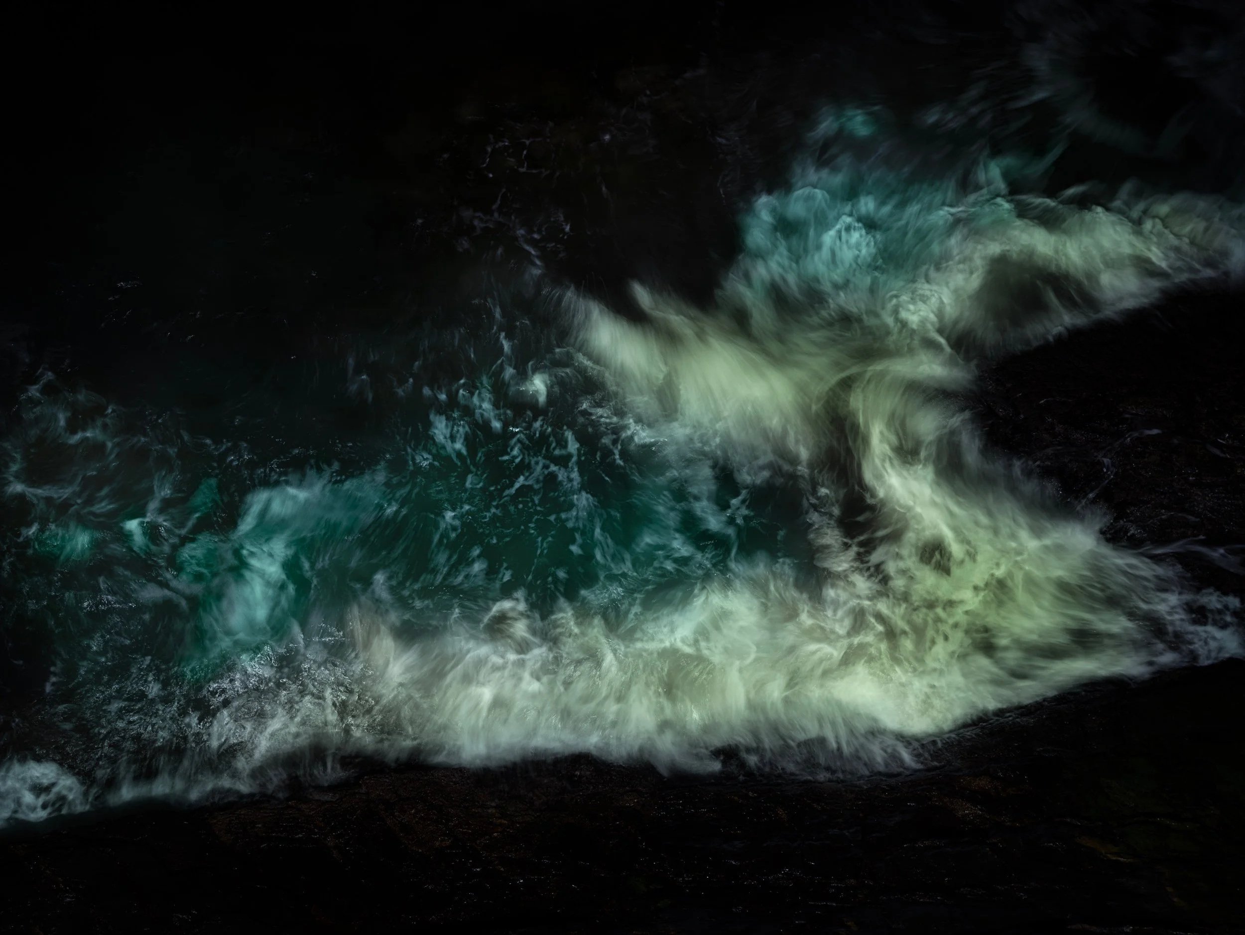 Dark water currents with some greenish-white foam and movement in a black environment