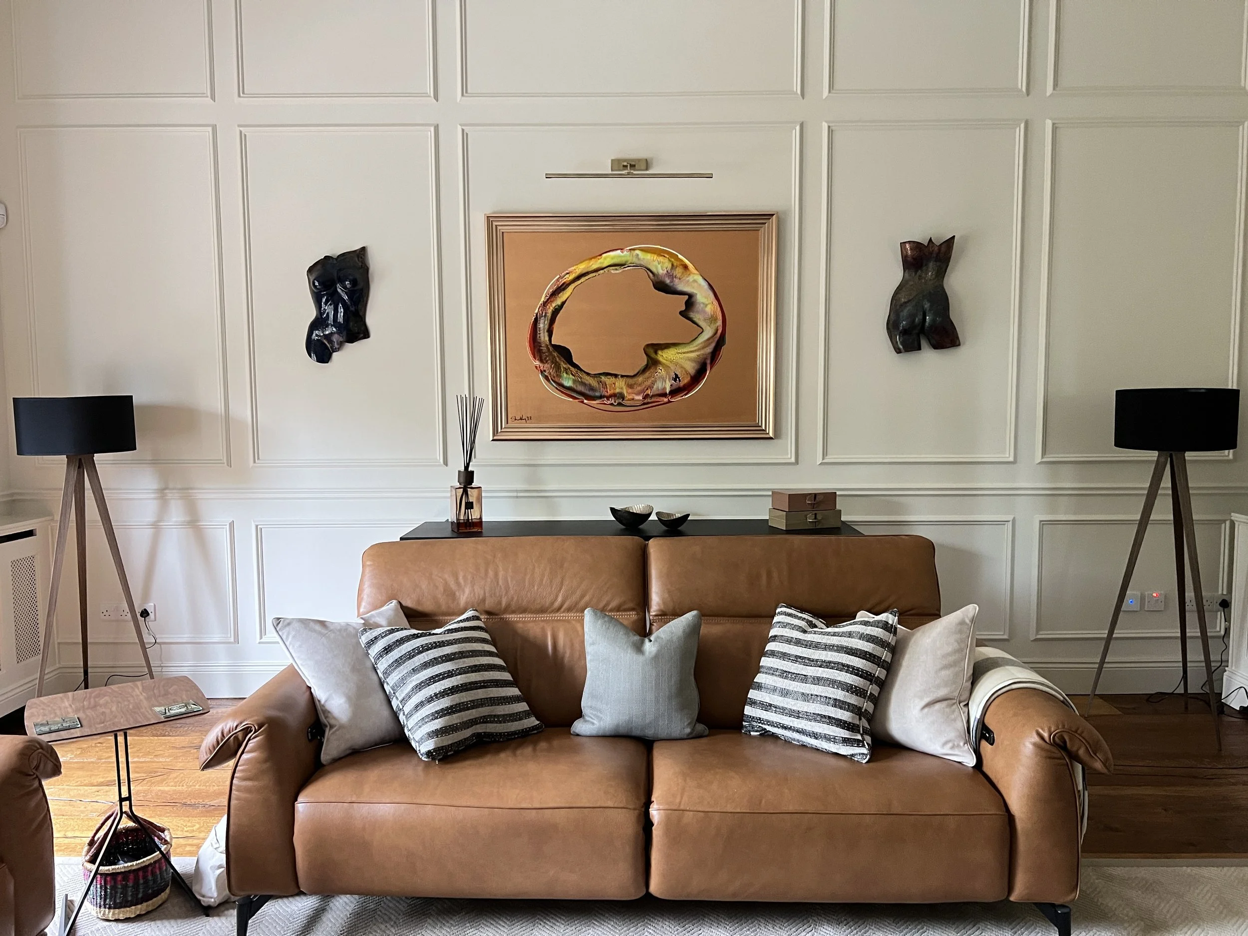 Neutral elegant living room, tan leather sofa. Kevin Sharkey art