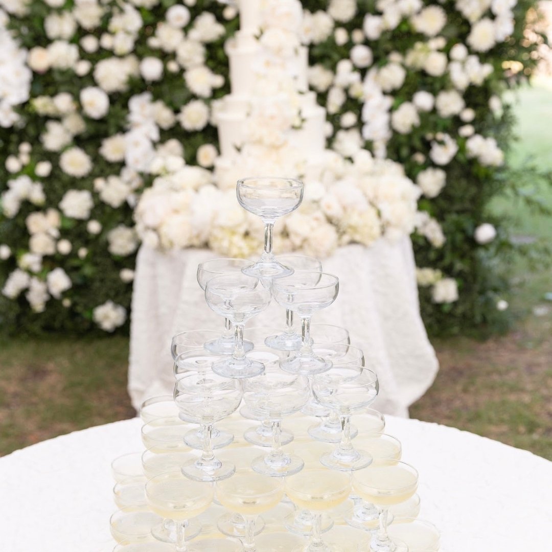 Nothing says &quot;celebration&quot; quite like a champagne tower, stacked as tall as your tiered wedding cake. 

This is such a fun approach to making a classic toast and kicking off your reception. Cheers! 🥂

#weddingcake #eventplanner #destinatio