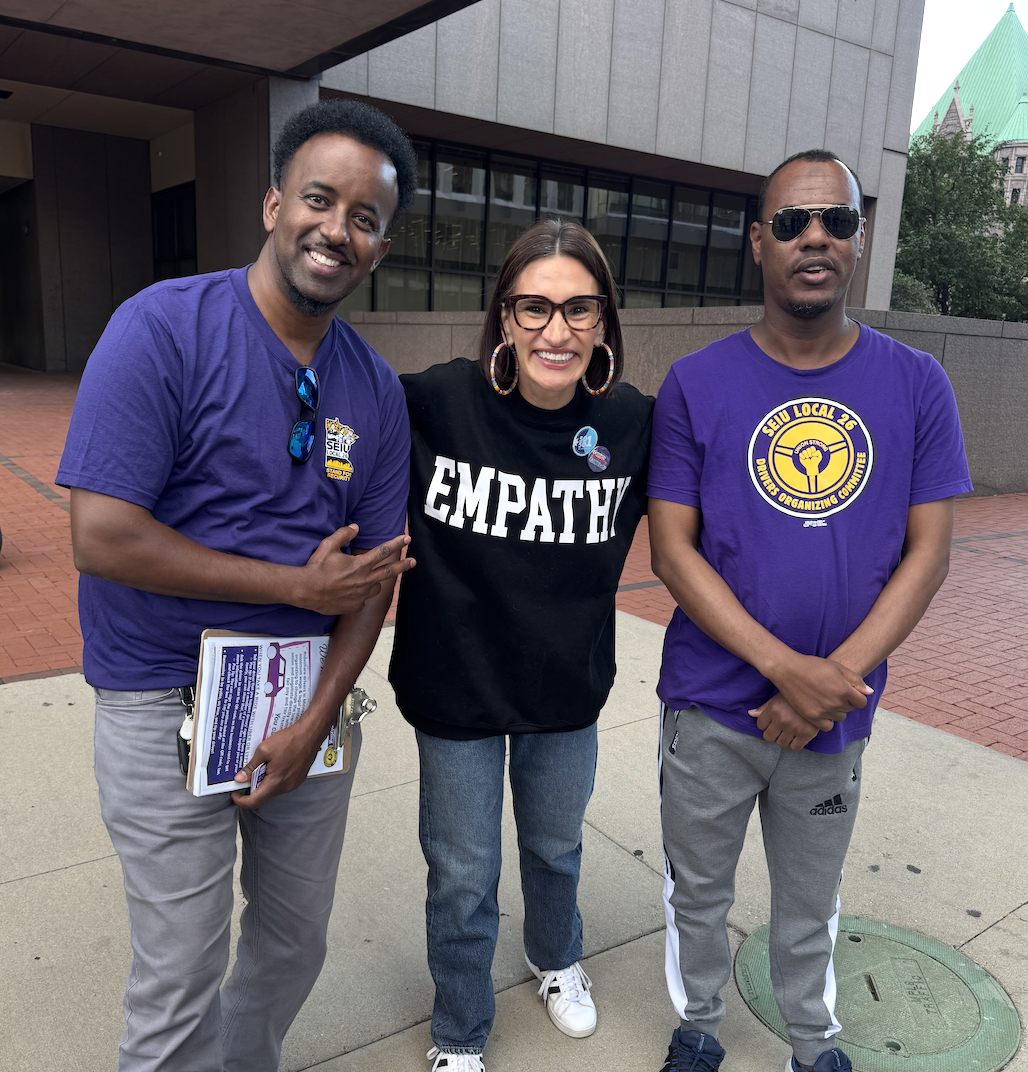 Peggy Flanagan with 2 men in purple SEIU tshirts
