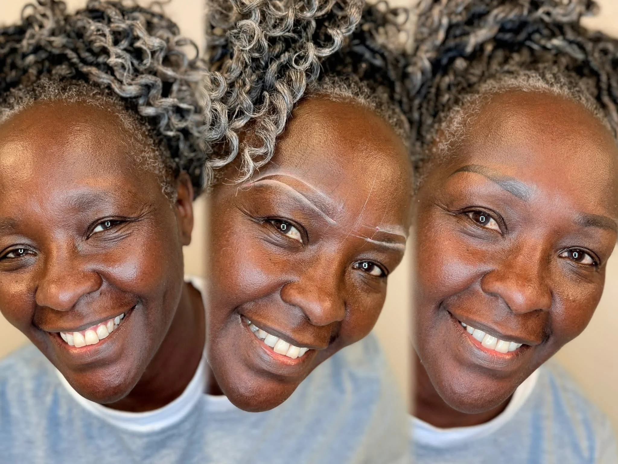 Three women with dark skin and gray curly hair smiling at the camera, with one woman in the center having white makeup details.