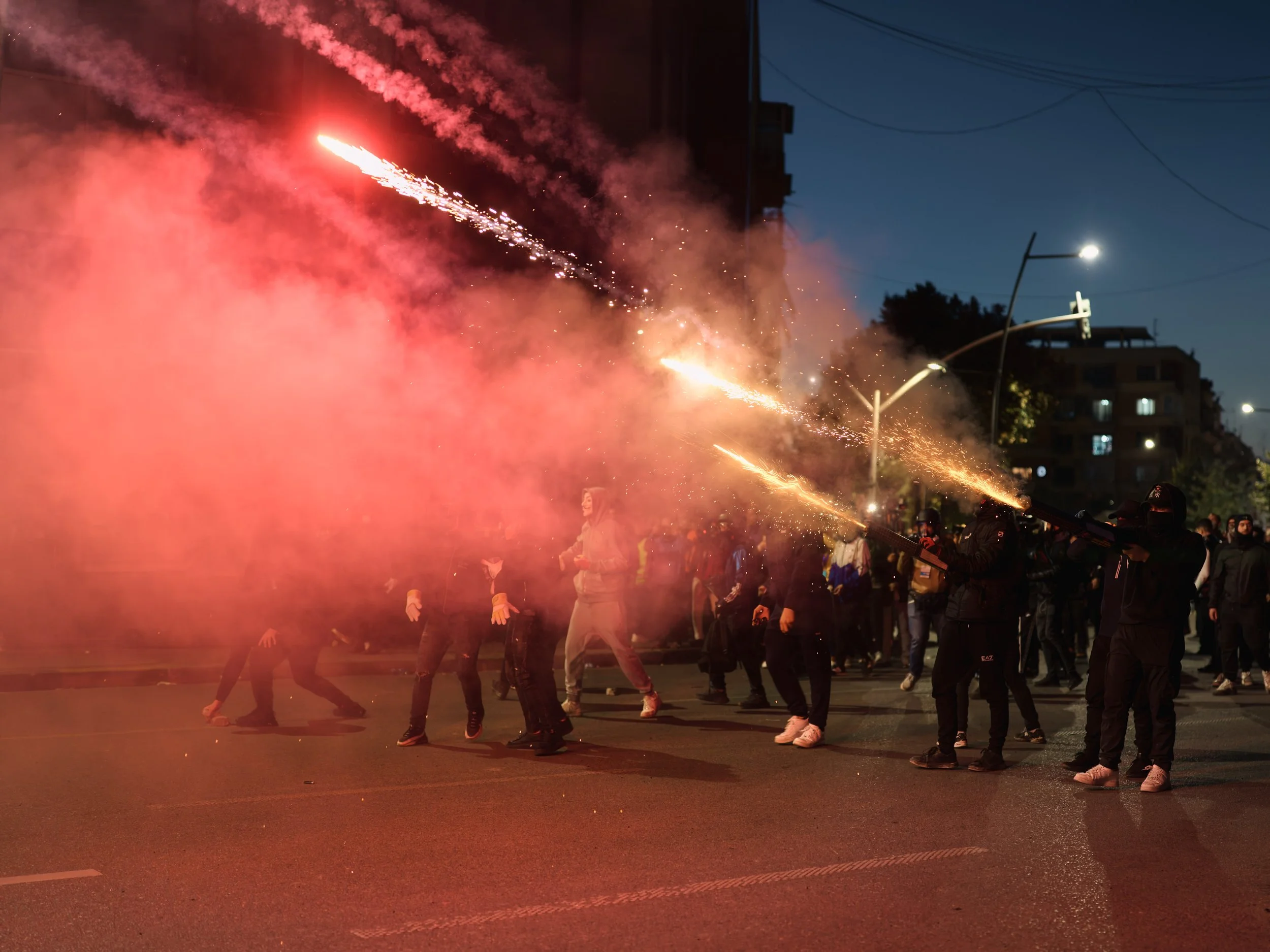 Demonstrators throw fireworks towards police officers.