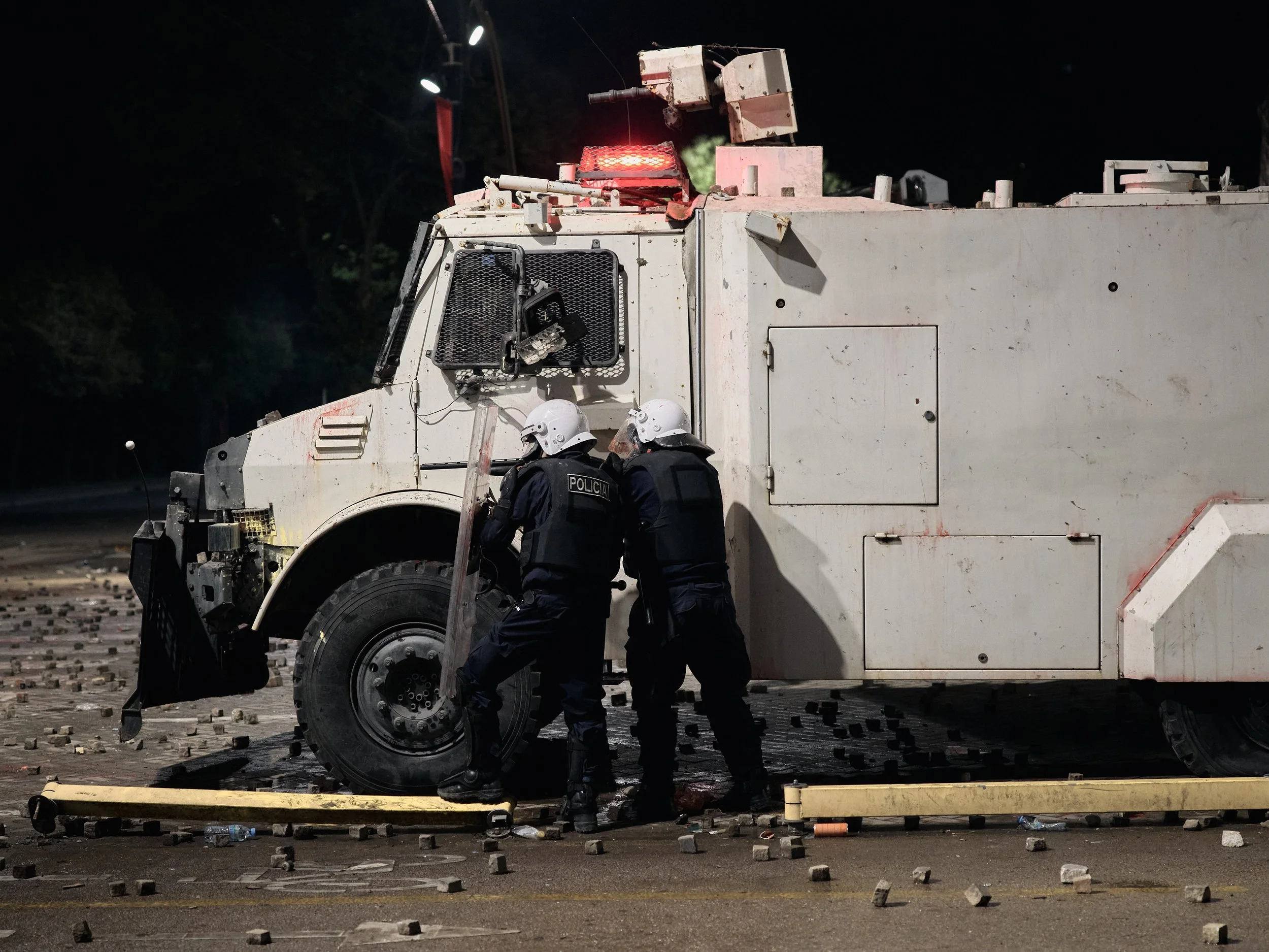 Two officers from RENEA, Albania’s special intervention unit, fire rubber bullets towards demonstrators.
