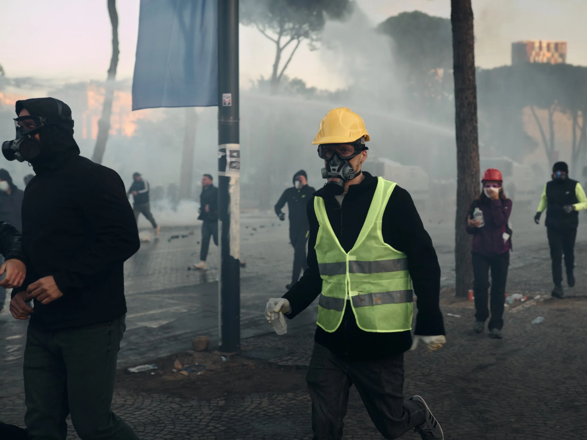 A first-aid volunteer runs towards demonstrators to assist those affected by tear gas.