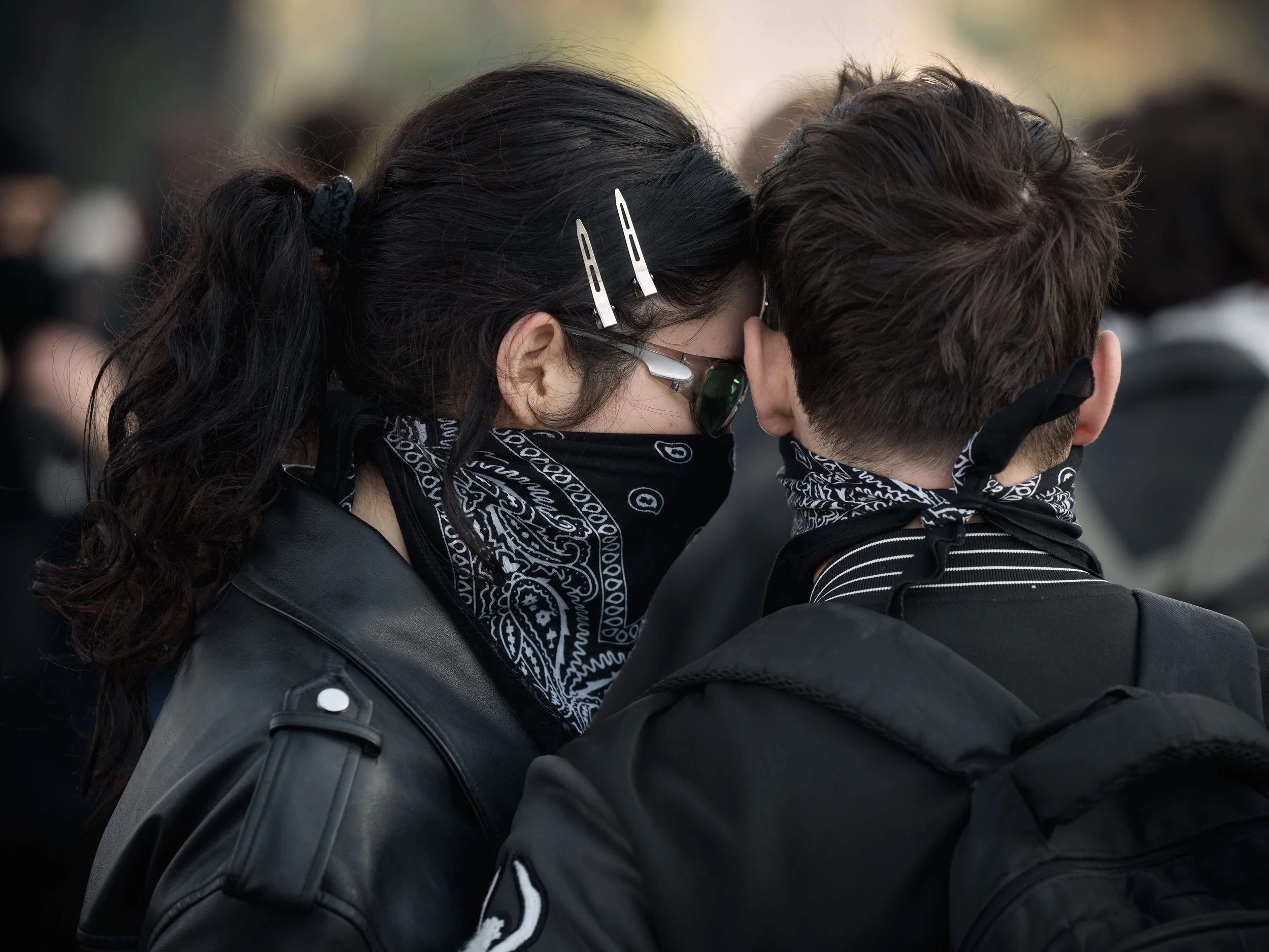 Two students stand close together as clashes between police and demonstrators intensify along the boulevard in front of the Prime Minister’s Office.