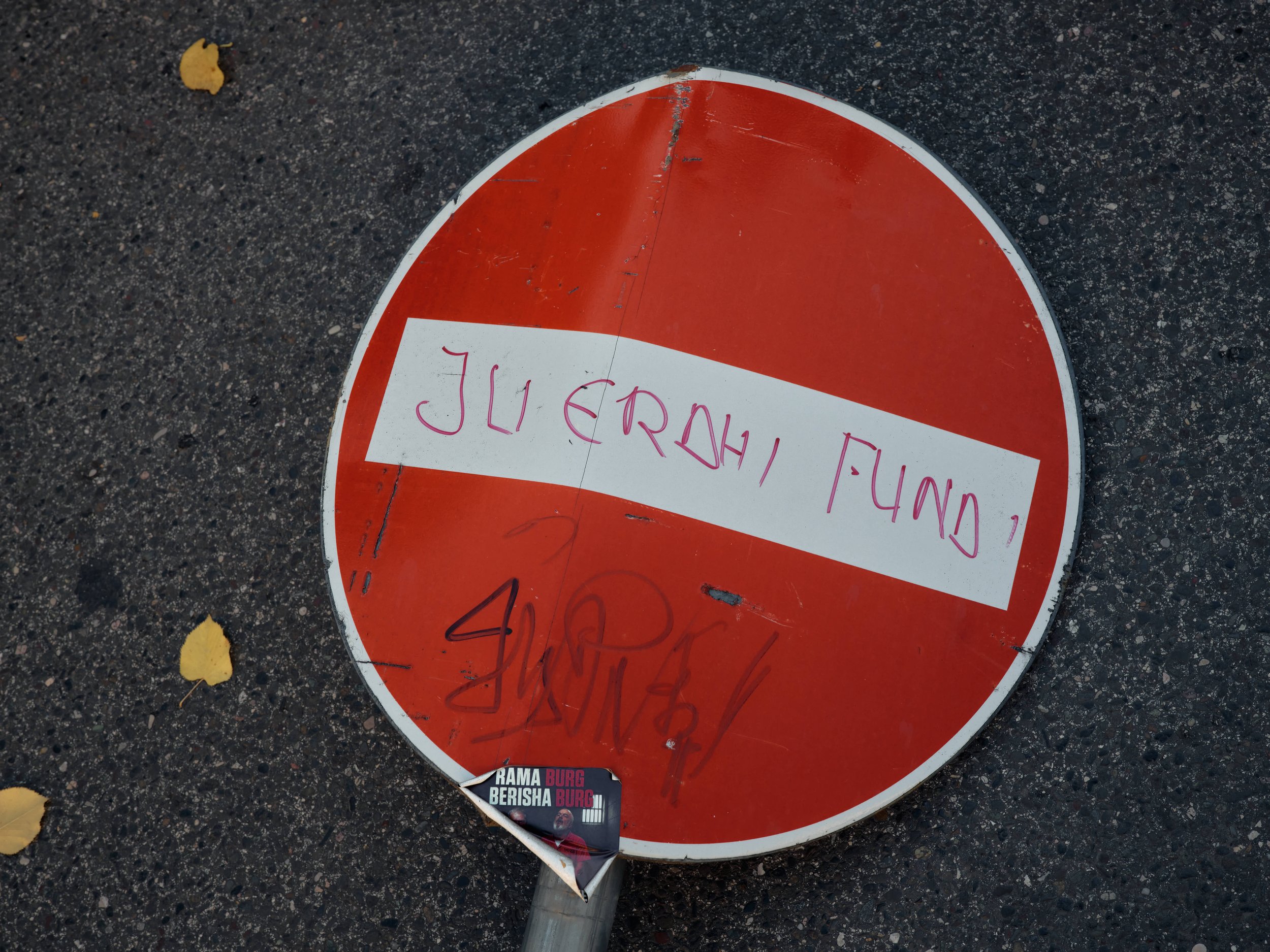A street sign uprooted by demonstrators bears the words “Your End Has Come,” one of the main slogans used by protesters since the beginning of the Flamingo Revolution, referring to the country's political establishment.