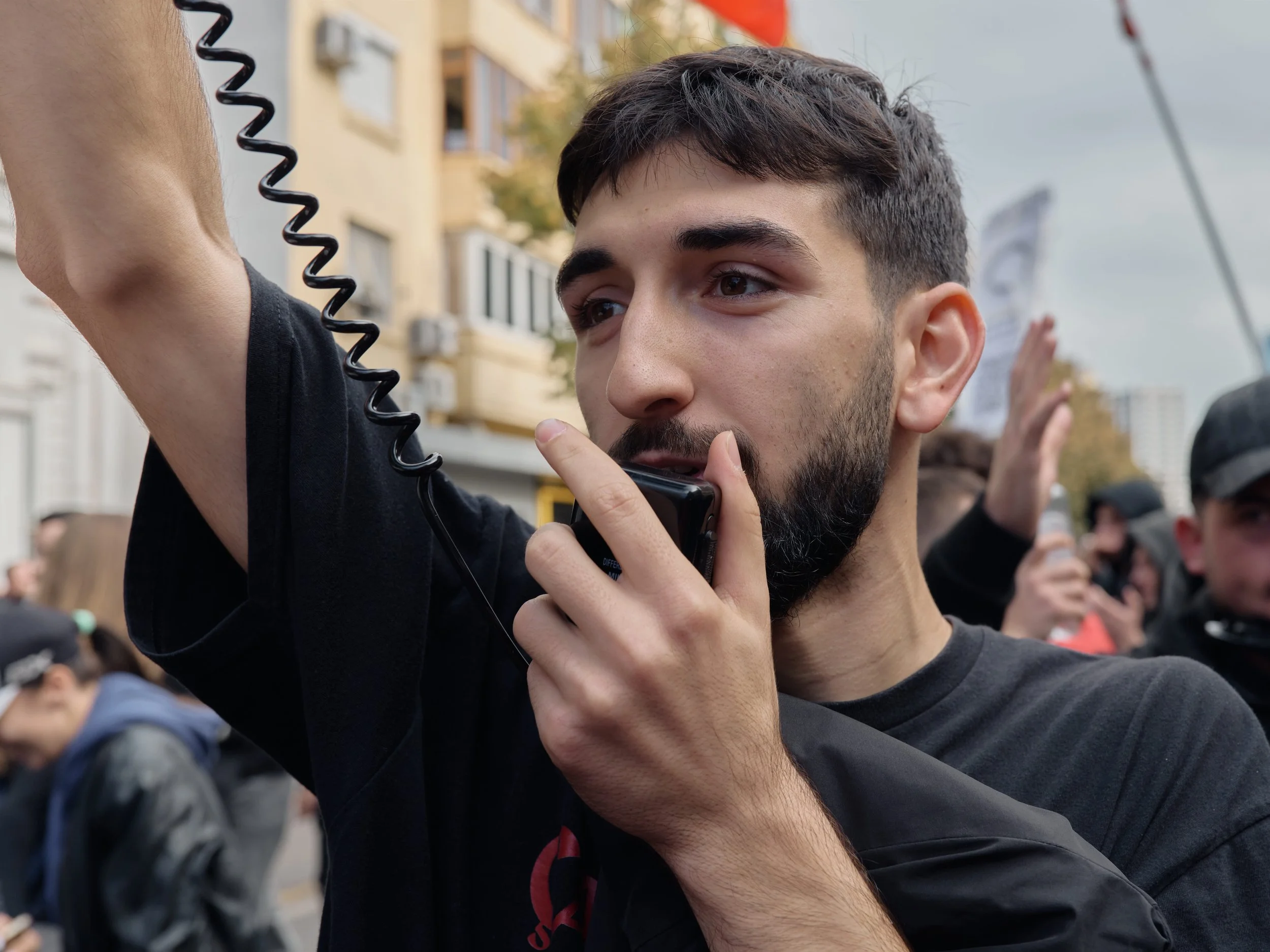 A student addresses demonstrators through a megaphone during a march towards the Ministry of Education.