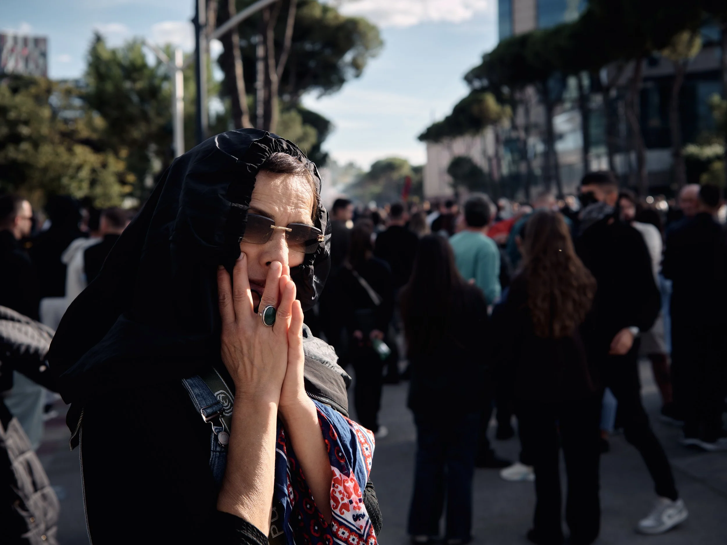 A woman covers her face with a scarf moments after a stun grenade explodes as police begin deploying the devices against demonstrators.