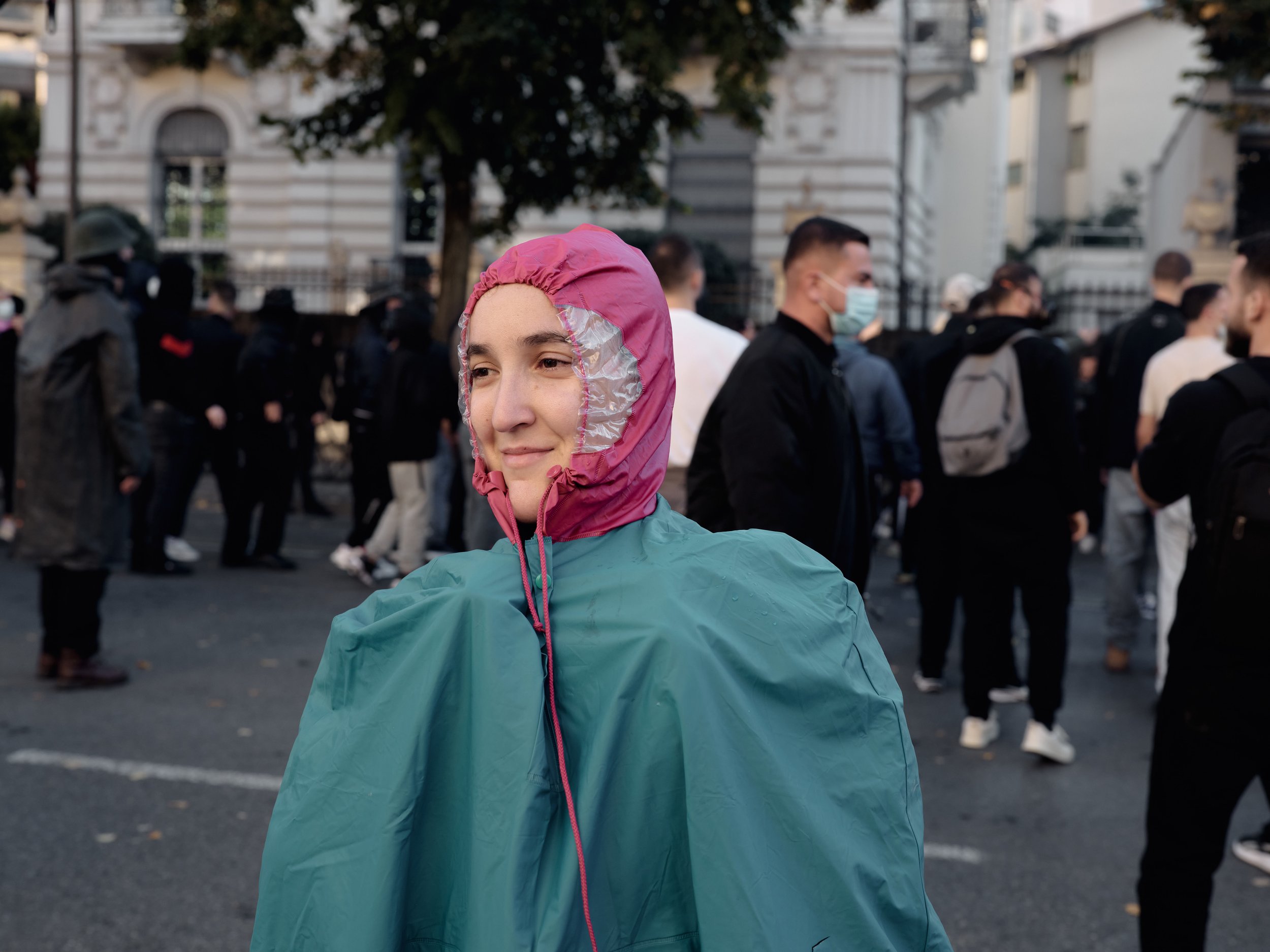 A student covers herself with a raincoat as police use water cannons against demonstrators.