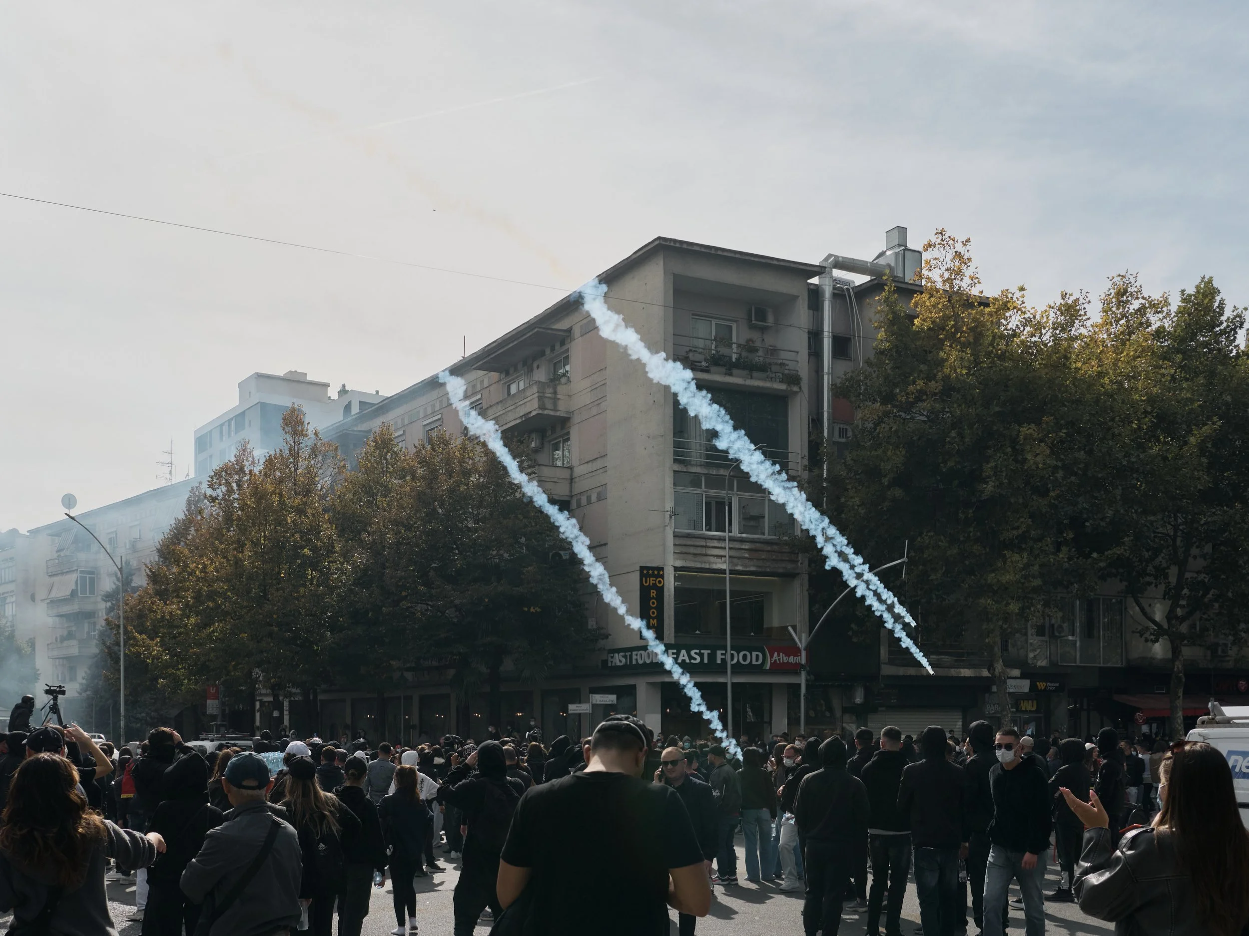 Three tear gas canisters fly over demonstrators heading towards the headquarters of the governing Socialist Party.