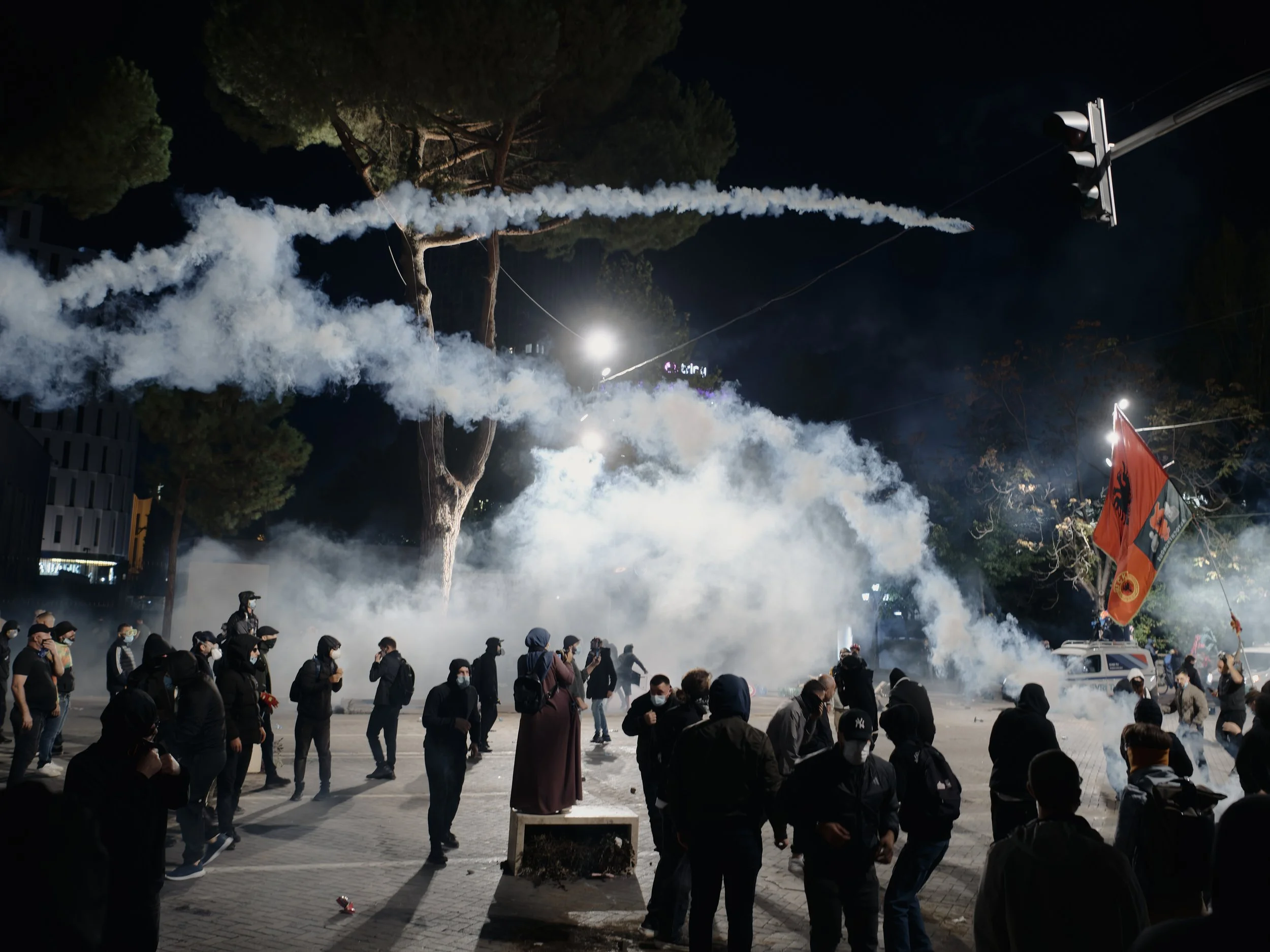 The boulevard is engulfed in tear gas as demonstrators throw a tear gas canister back towards police.
