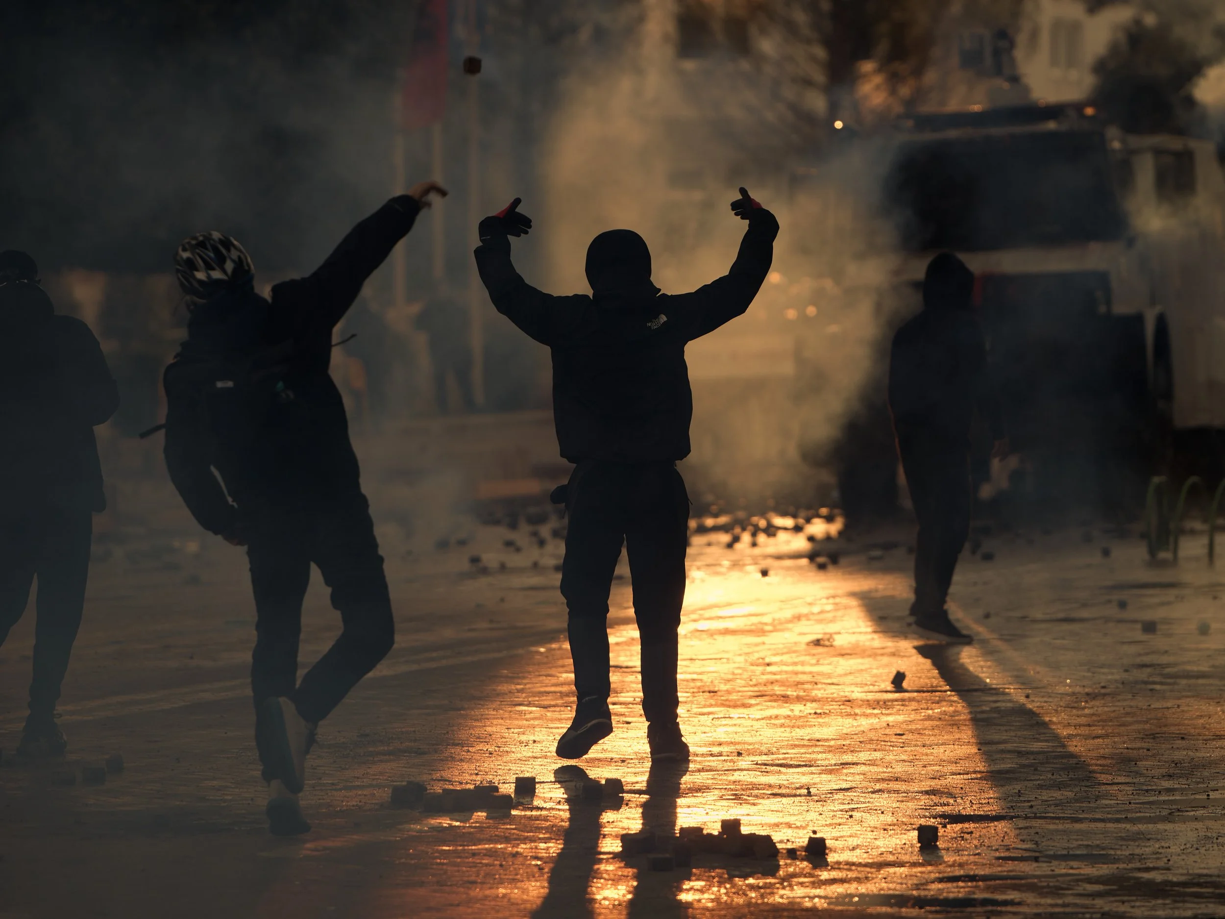 Demonstrators throw stones taken from the boulevard towards police officers in front of the Prime Minister’s Office.