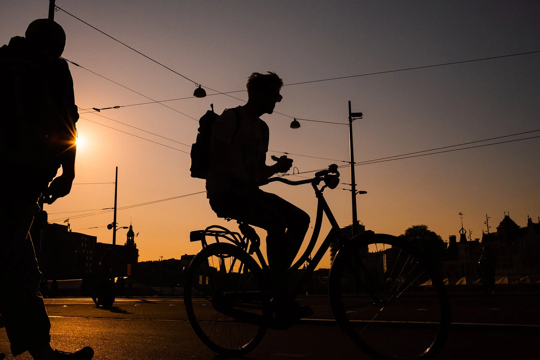 Biker in Amsterdam Netherlands in sunset, photographed by travel documentary photographer Toni Smailagic with Fuji X100V