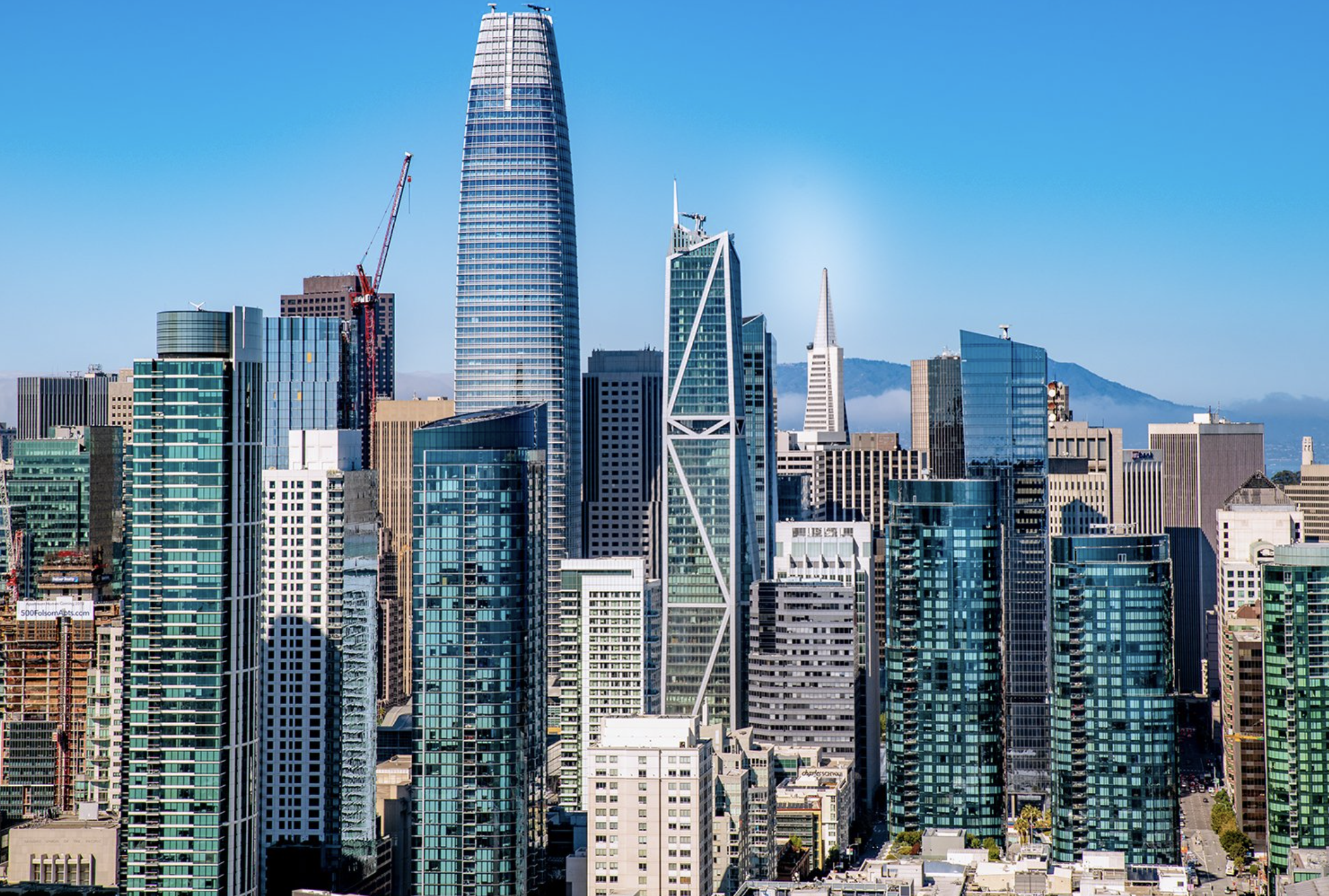 San Francisco skyline featuring modern skyscrapers with the Transamerica Pyramid in the distance on a clear day.