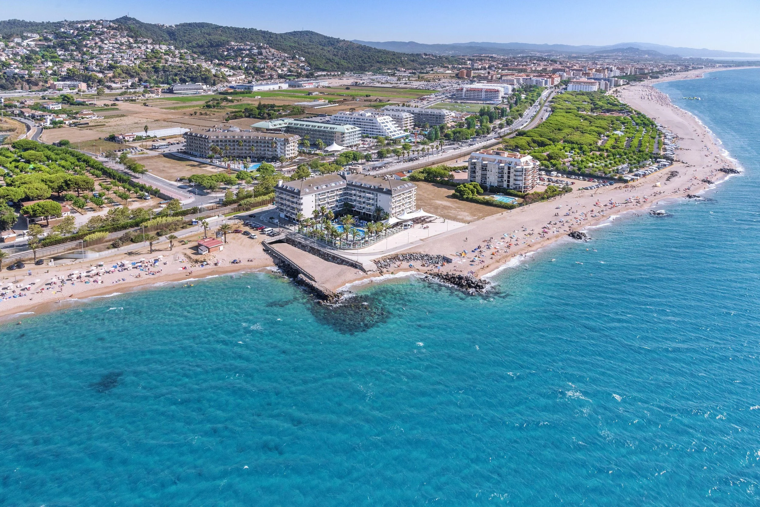 Vista aérea de Caprici Beach Hotel & Spa junto a la playa de Santa Susanna, Barcelona, con la costa mediterránea al fondo