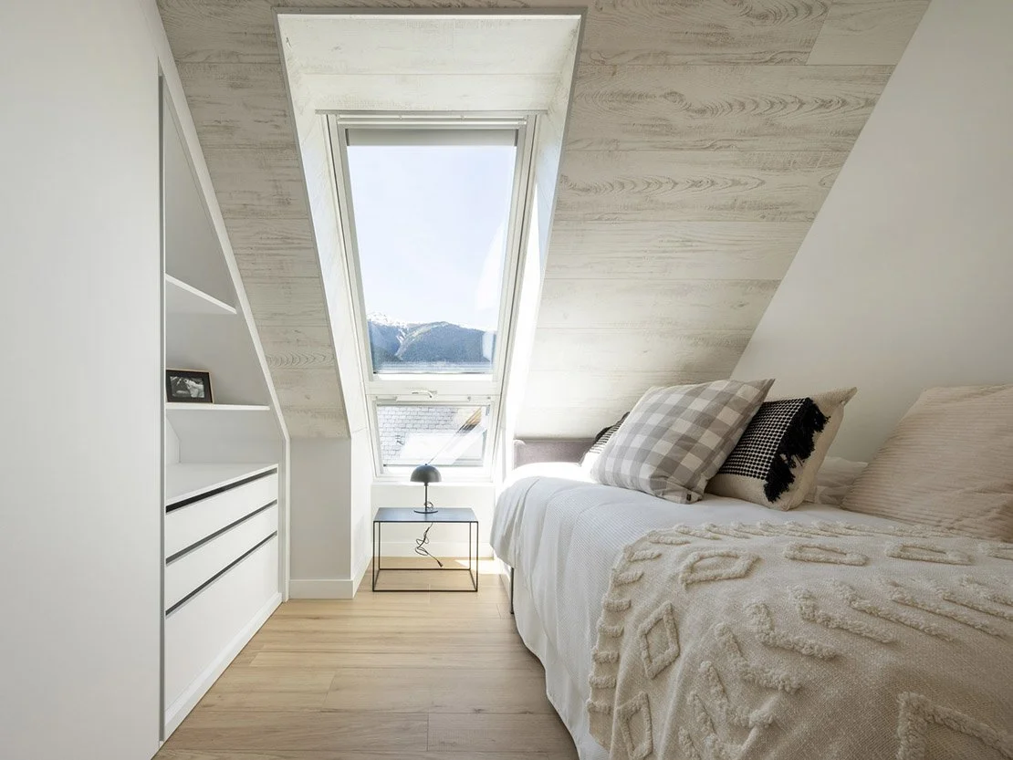 Dormitorio abuhardillado de Residencial Els Pletieus, con ventana velux y vistas a las montañas nevadas