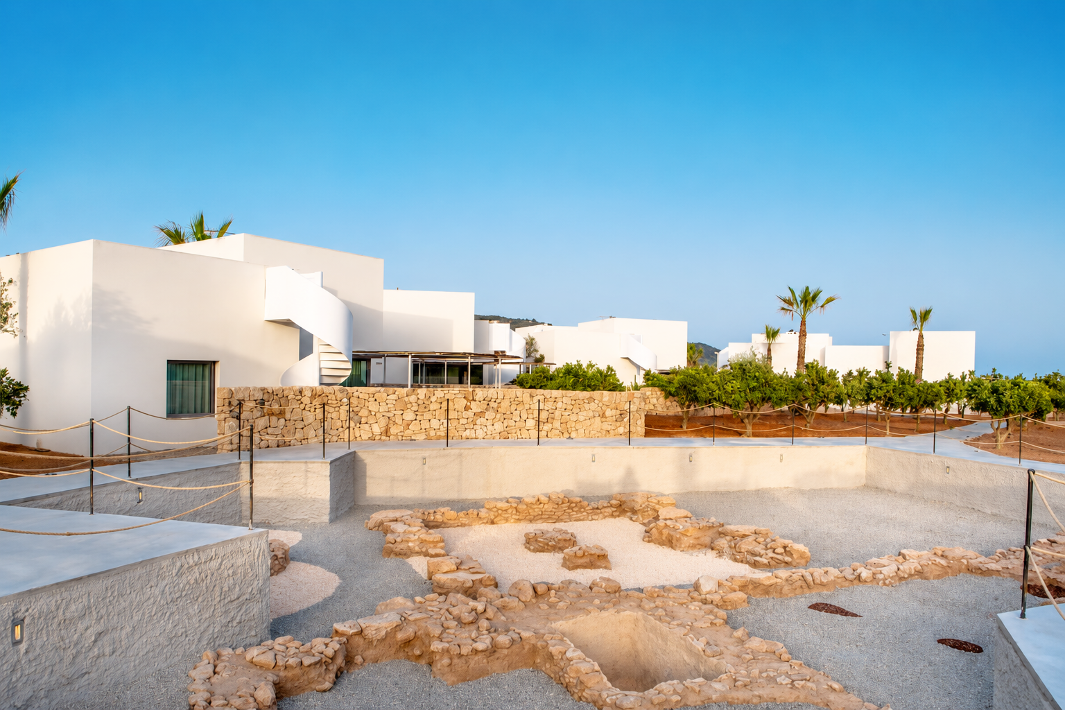 Arquitectura blanca de estilo ibicenco en Can Jaume, con restos arqueológicos conservados en el jardín