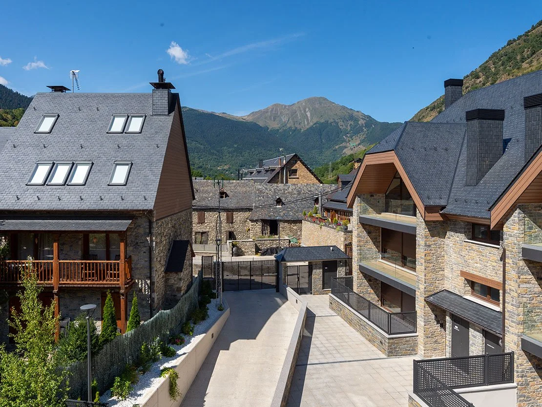Vista exterior de Residencial Els Pletieus, con tejados tradicionales de pizarra y las montañas del Valle de Arán al fondo