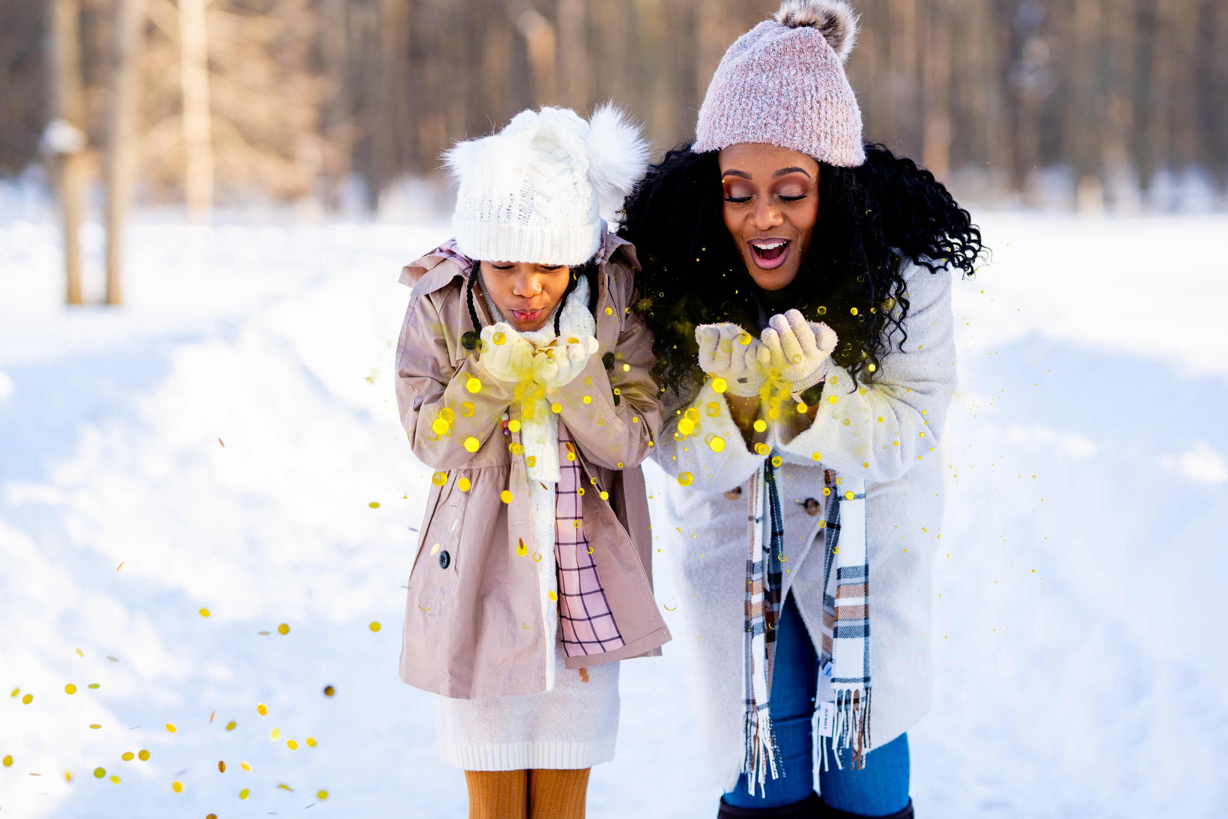 mother and daughter blowing glitter in the snow