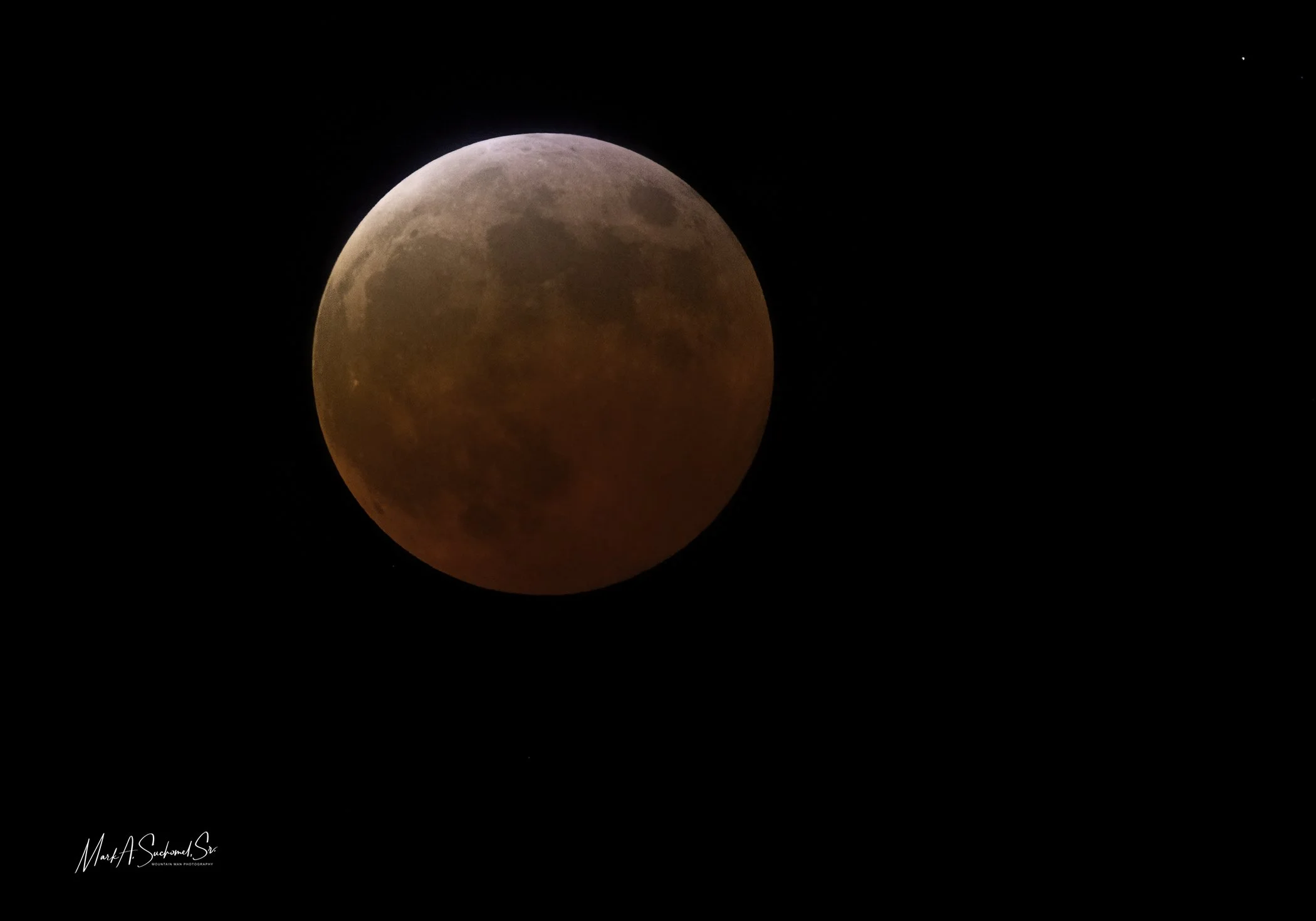 A photo of a blood moon against a dark night sky.