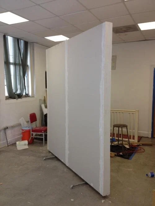 freshly built free standing wall divider in an art gallery