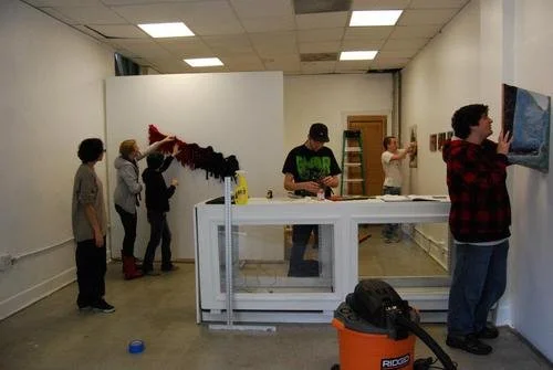 students installing artwork in a gallery