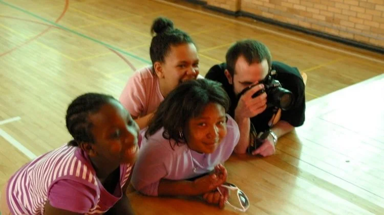 students and teacher using camera together