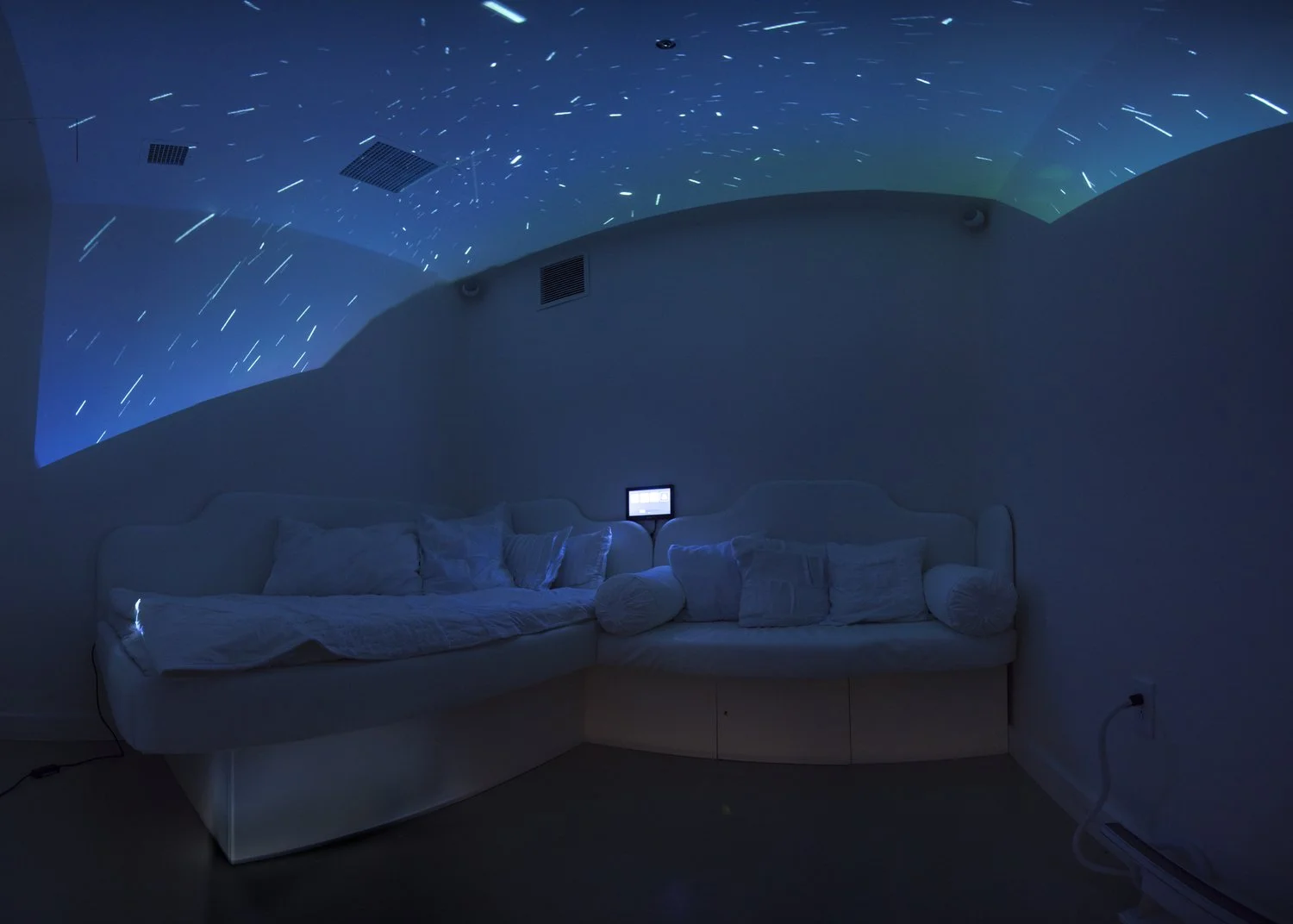 therapeutic water bed and caregiver seating in medical setting under dark night themed animated lights