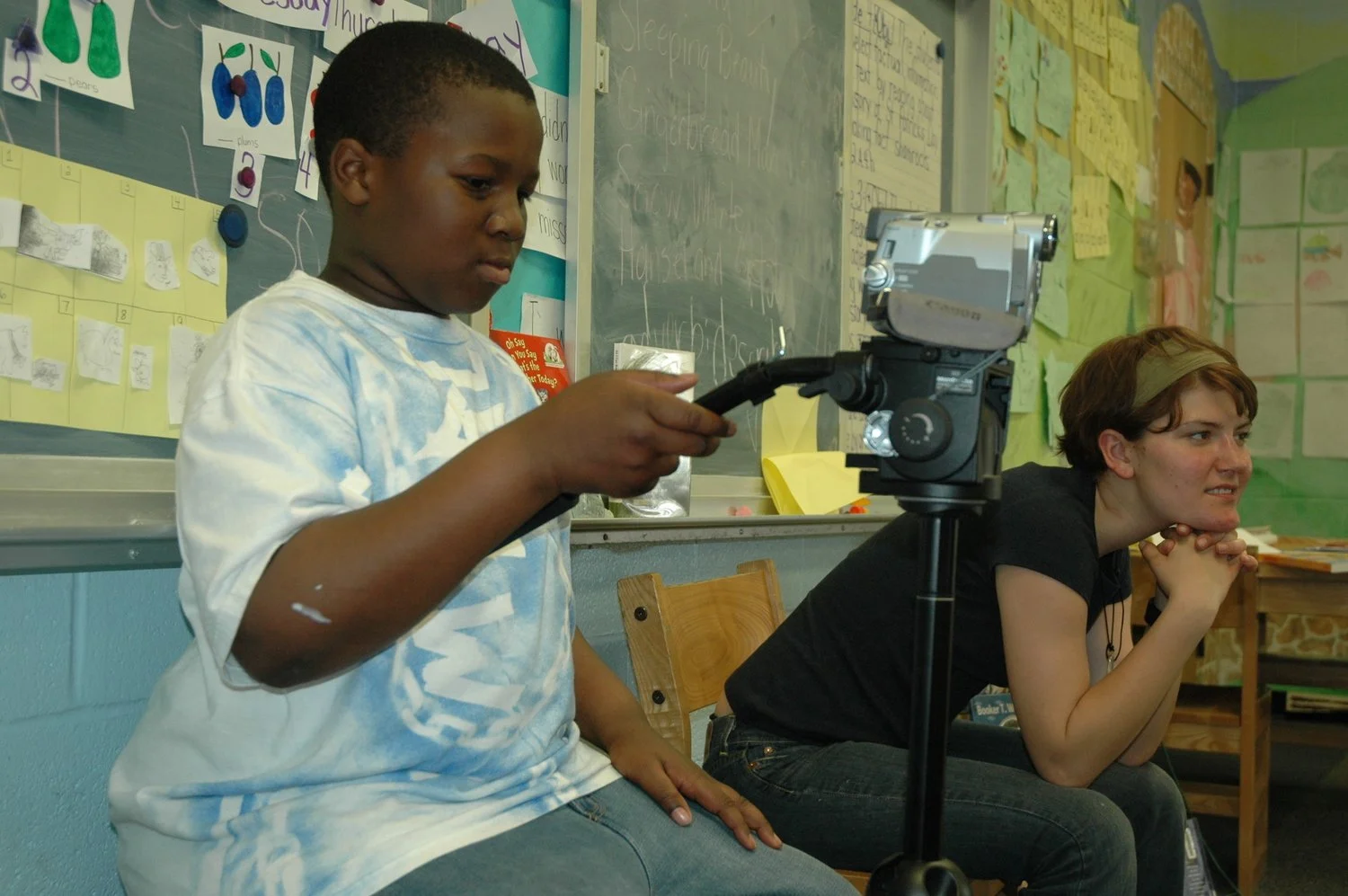 young boy and college student operate video camera together